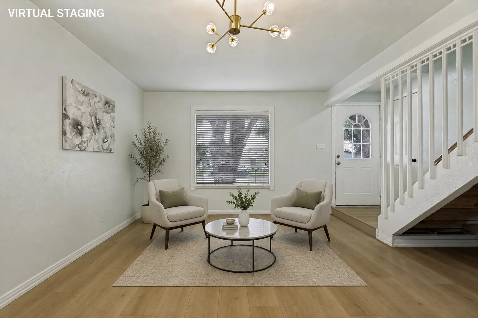 Hardwood-finish flooring, staircase with white balusters, transom window above the entry door, and a contemporary light fixture