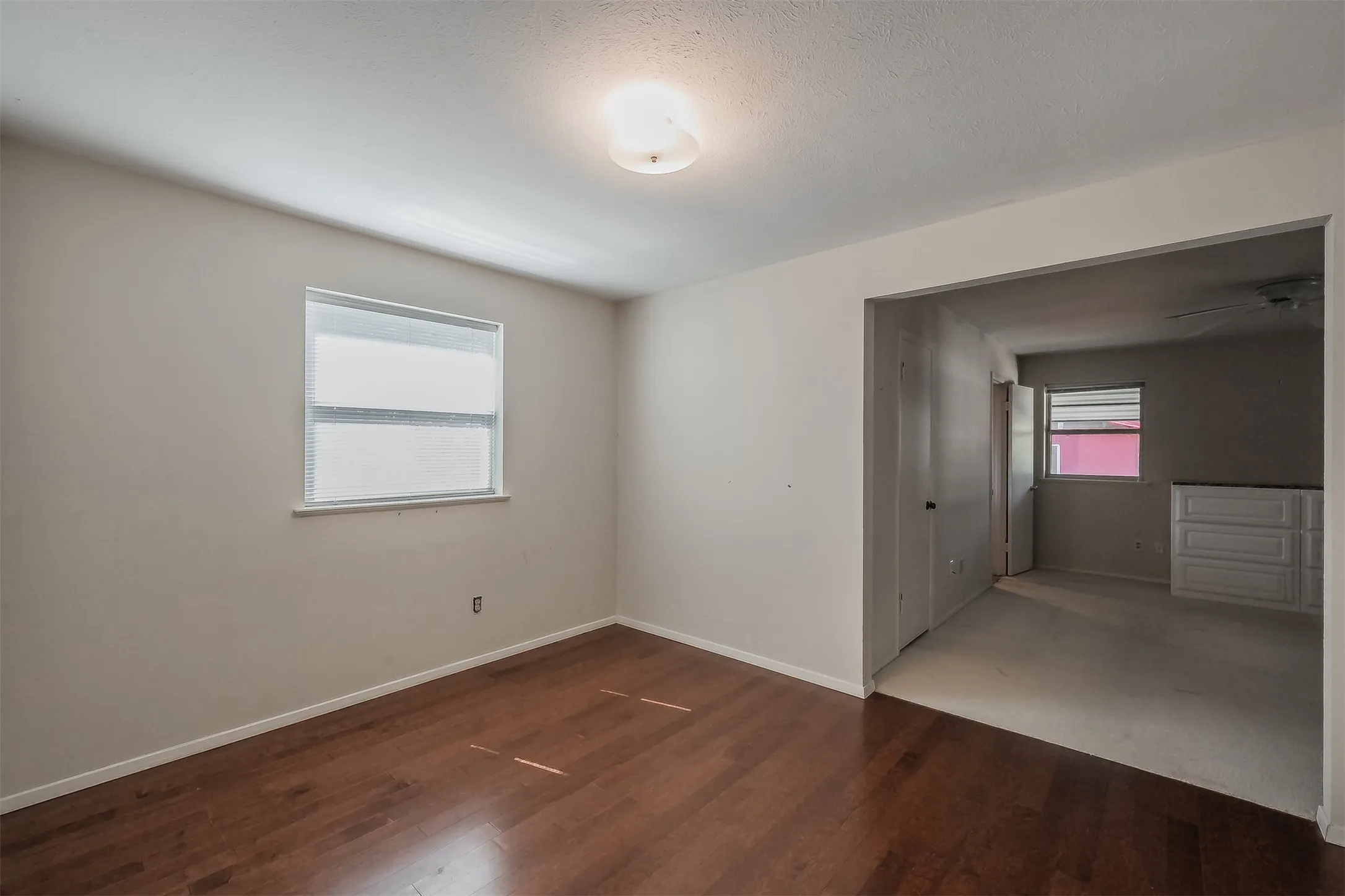 Hardwood flooring, neutral wall tones, recessed window, flush-mount ceiling light