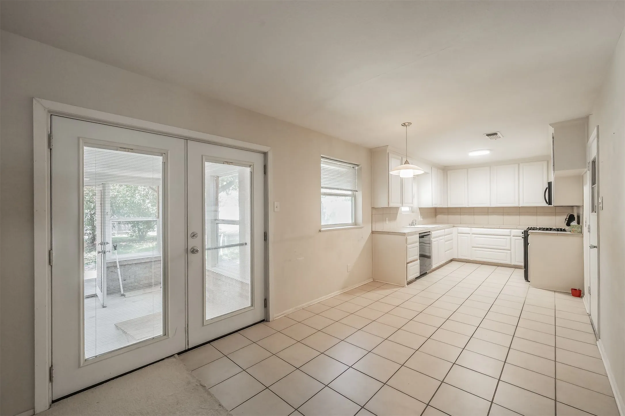 Kitchen featuring white cabinetry, tile flooring, and a tile backsplash