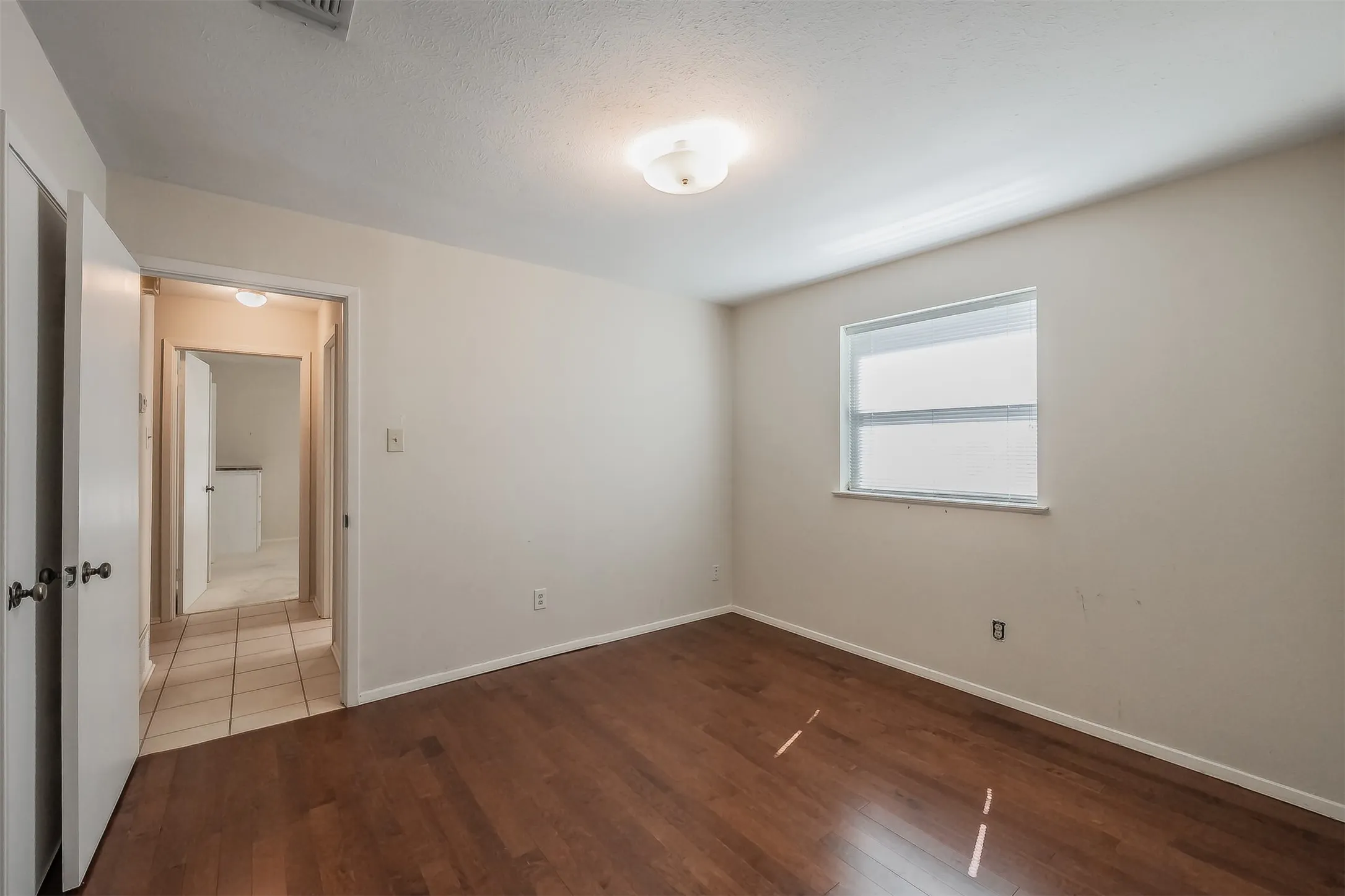 Wood-finish flooring, single window, flush-mount ceiling light