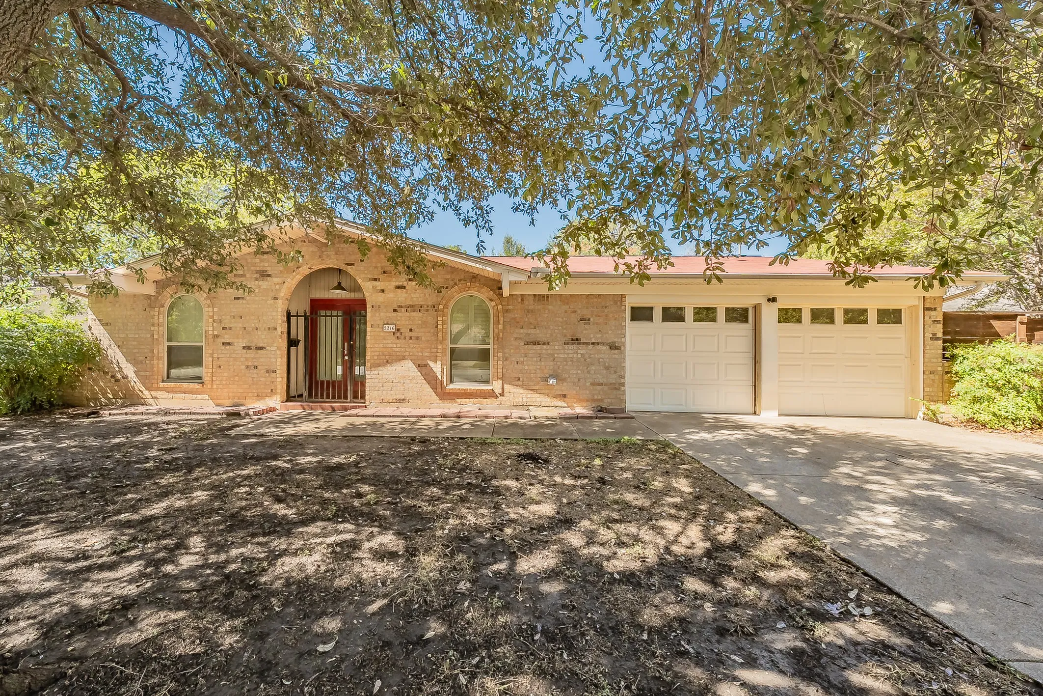 Brick exterior with arched entryway and red security door