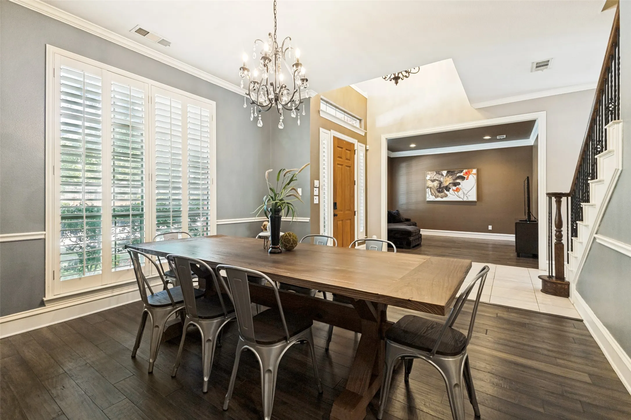Dining area with a sophisticated dark wood-finish floor and a crystal chandelier