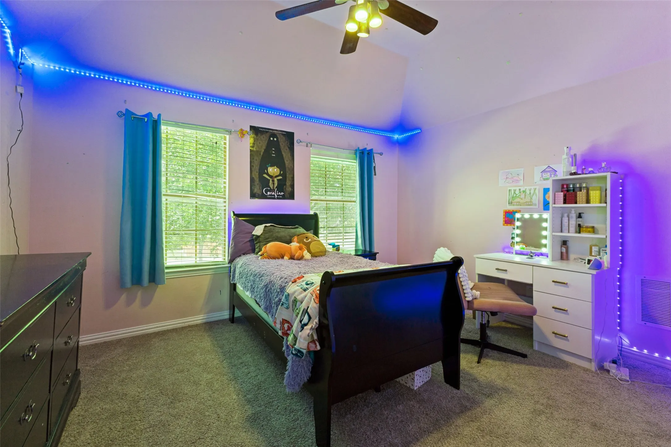 Carpeted room featuring a vaulted ceiling and a ceiling fan with integrated lighting