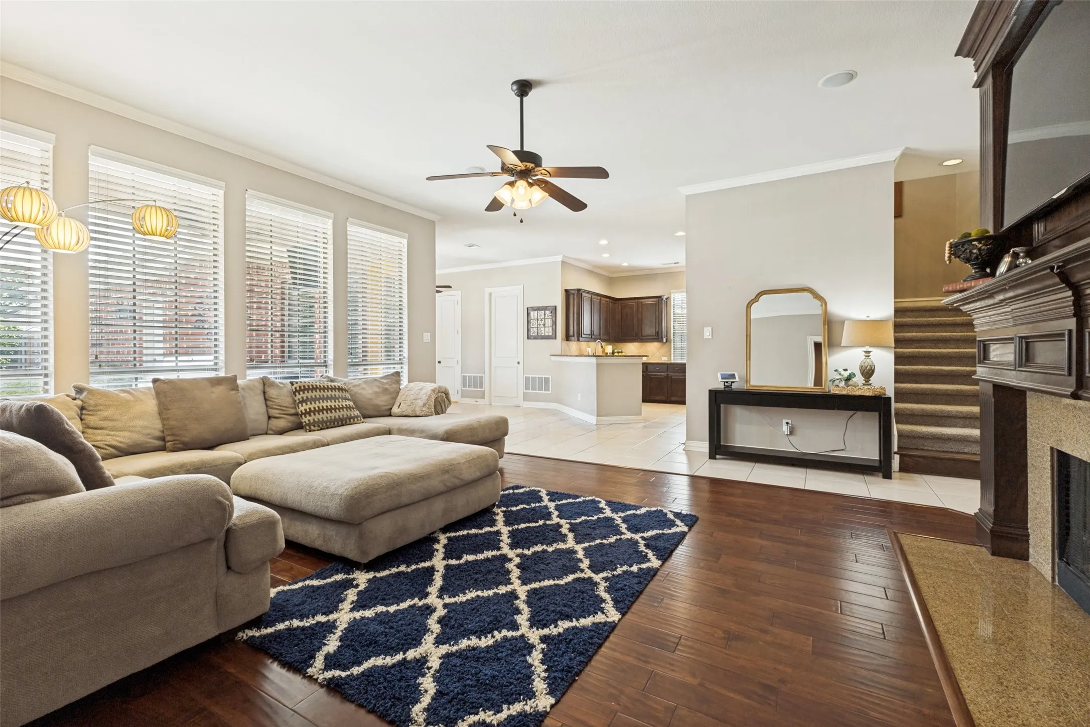 Living area featuring rich wood-finish flooring and multiple tall windows