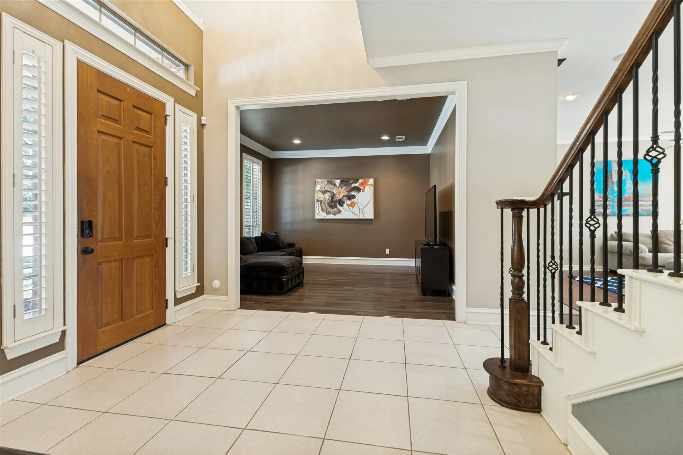 Entryway featuring tile flooring, a wood-paneled door, and sidelight windows with plantation​​‌​​​​‌​​‌‌​‌‌​​​‌‌​‌​‌​‌​​​‌​​ shutters