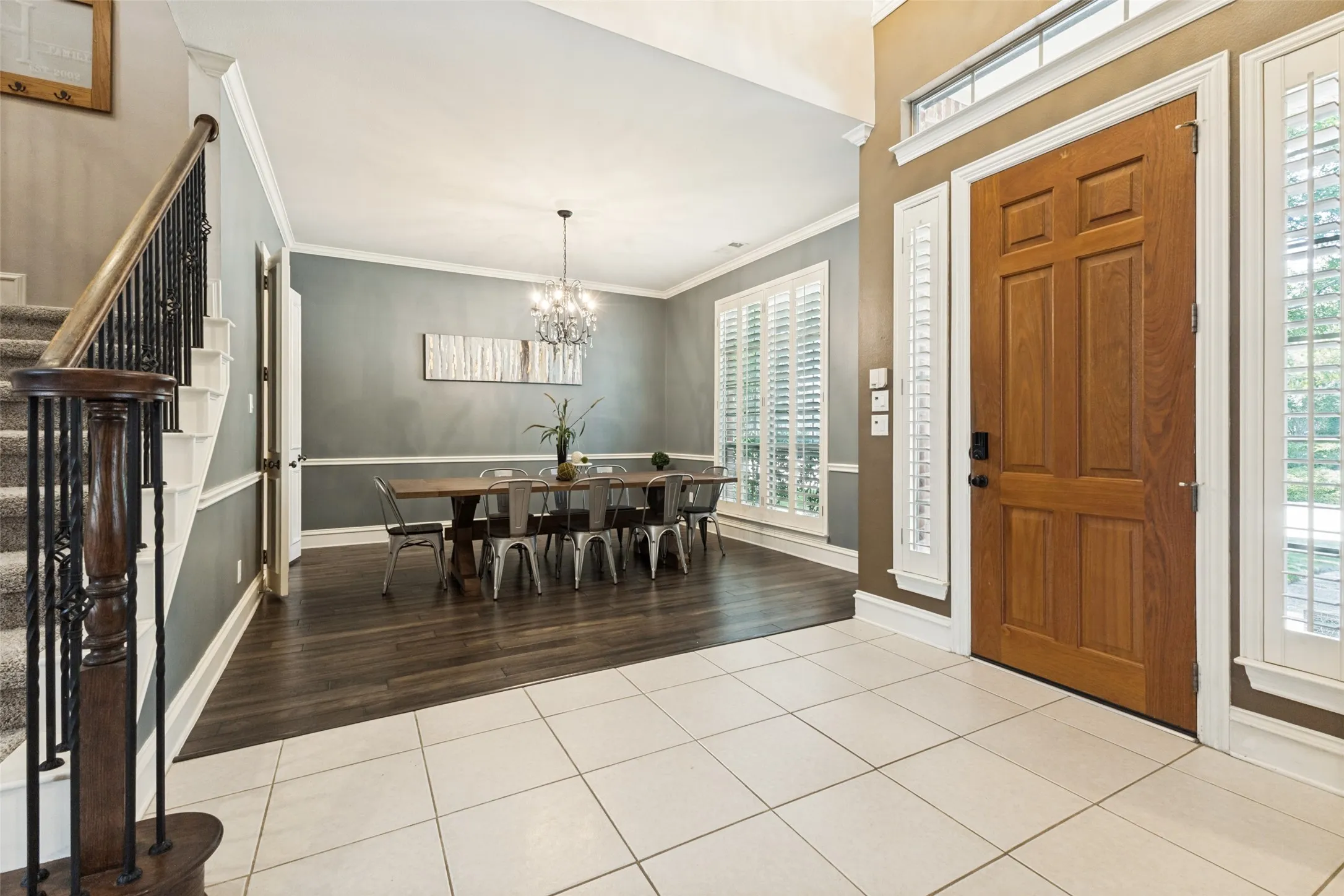 Gracious entryway featuring light-toned tile flooring and a paneled wood-finish door with sidelights