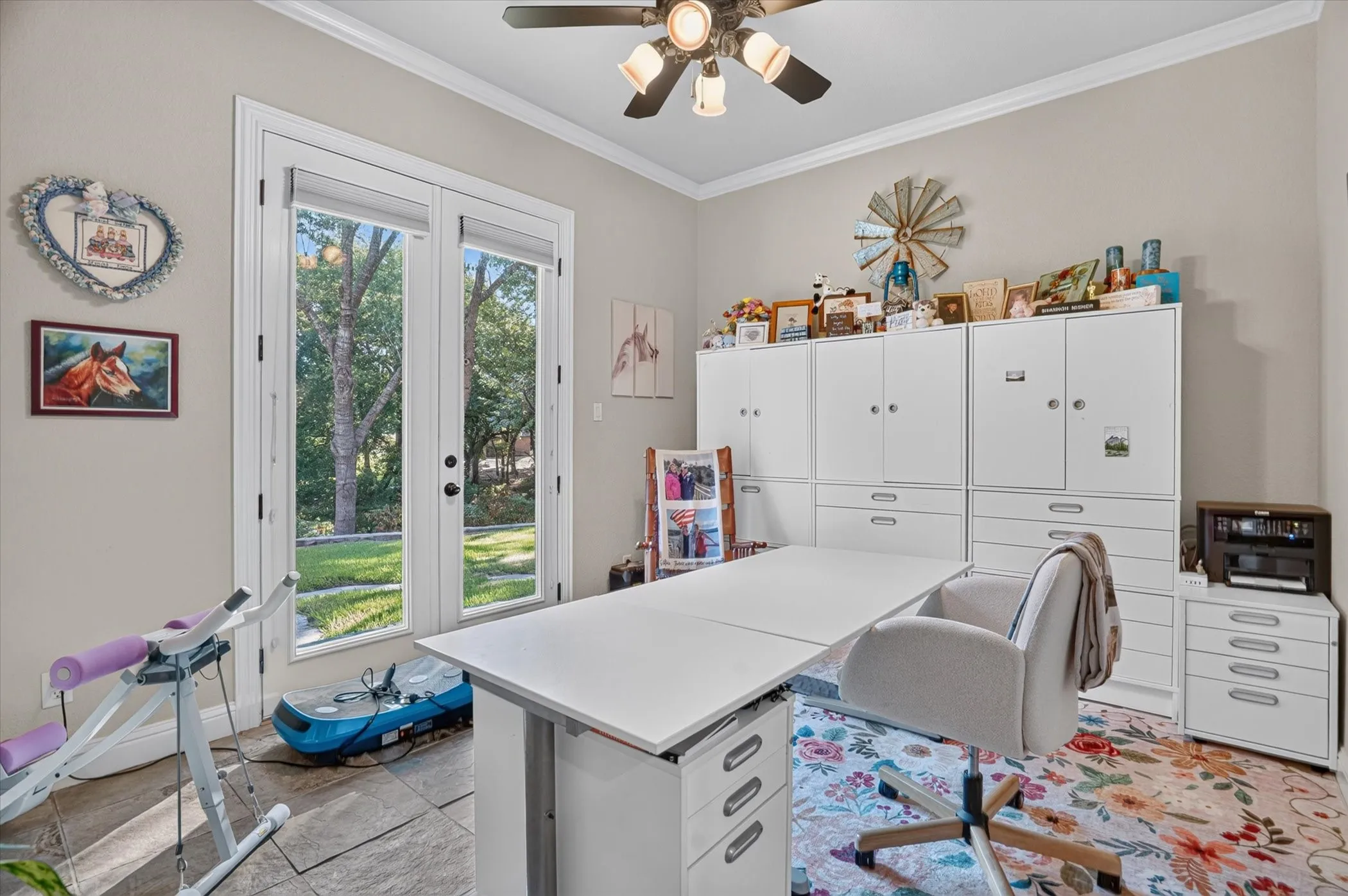 White double doors, crown molding, and a ceiling fan with integrated lighting