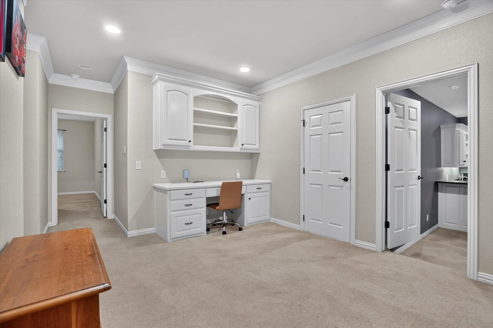 Built-in desk with overhead cabinetry, recessed lighting, and carpeted flooring