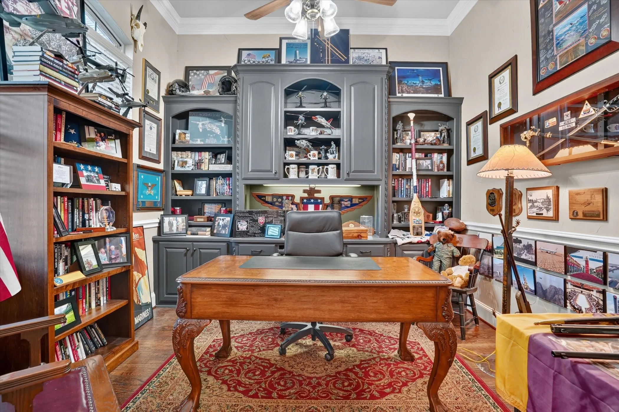 Hardwood flooring, crown molding, built-in cabinetry, ceiling fan, and chair railing.