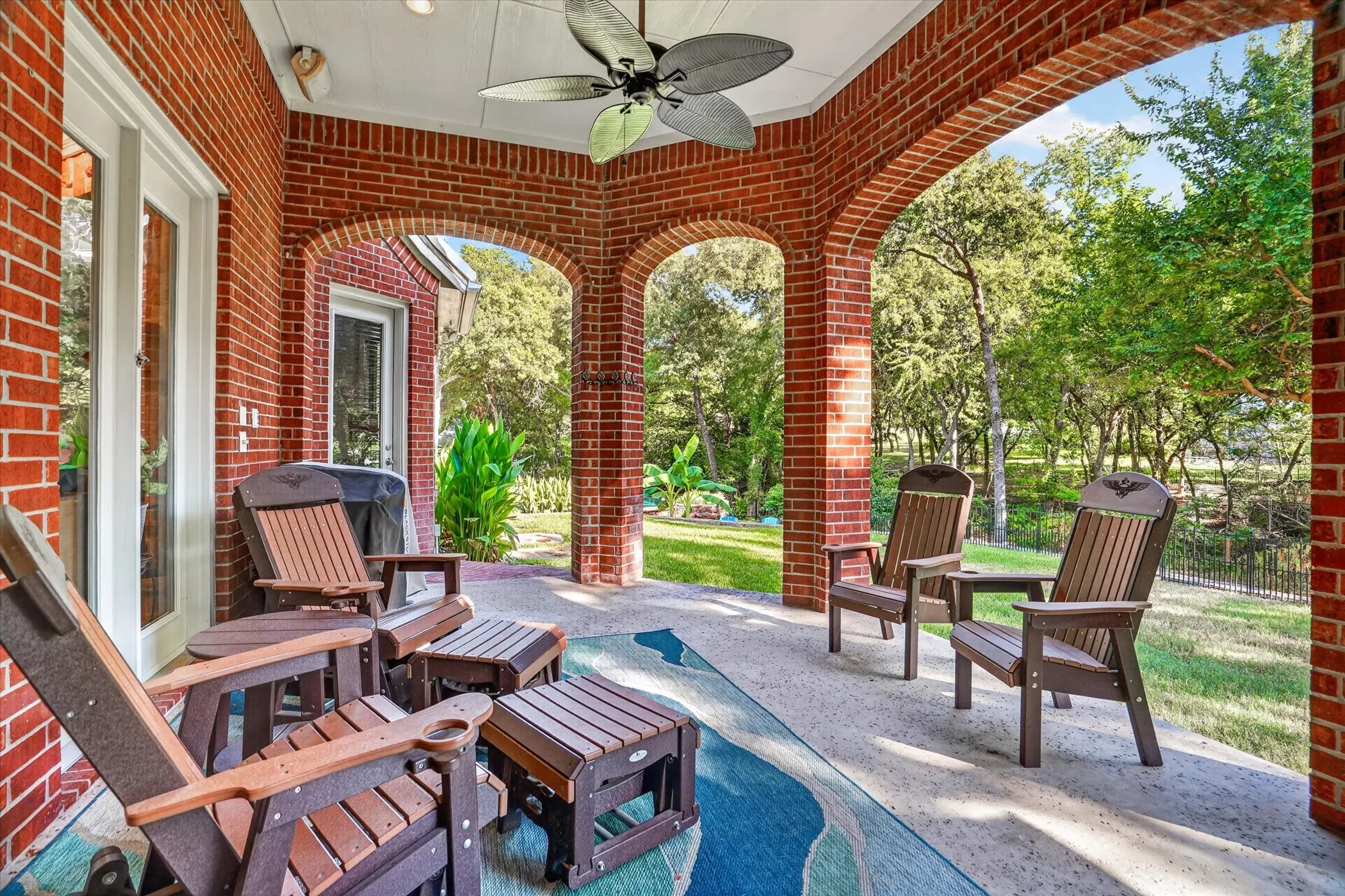 Covered patio featuring a brick exterior and arched openings