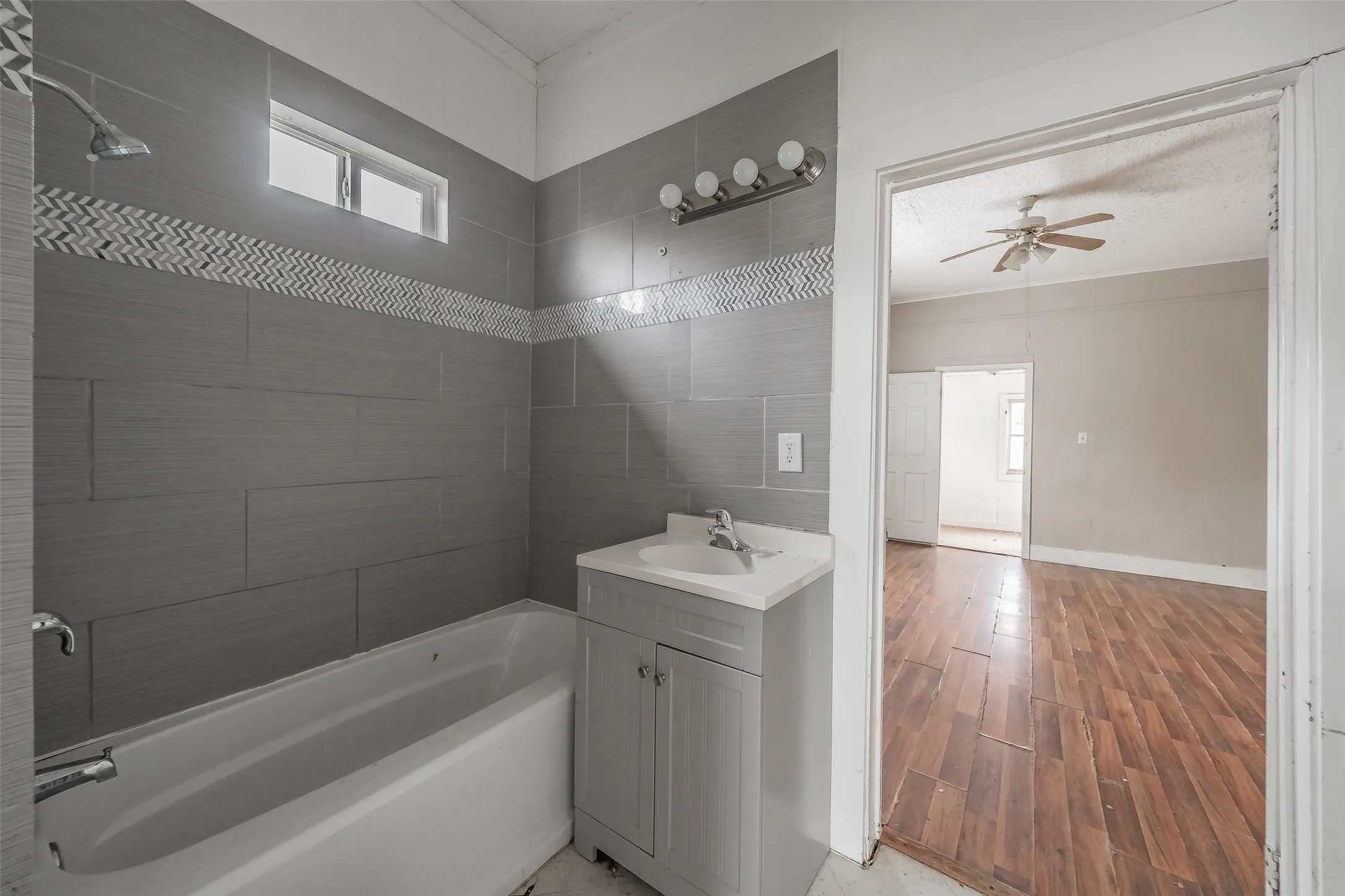 Gray tiled shower surround with a decorative mosaic border