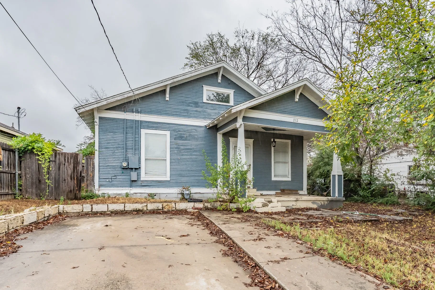 Gable roofline, covered front porch, exterior siding, concrete driveway, and front entry stairs