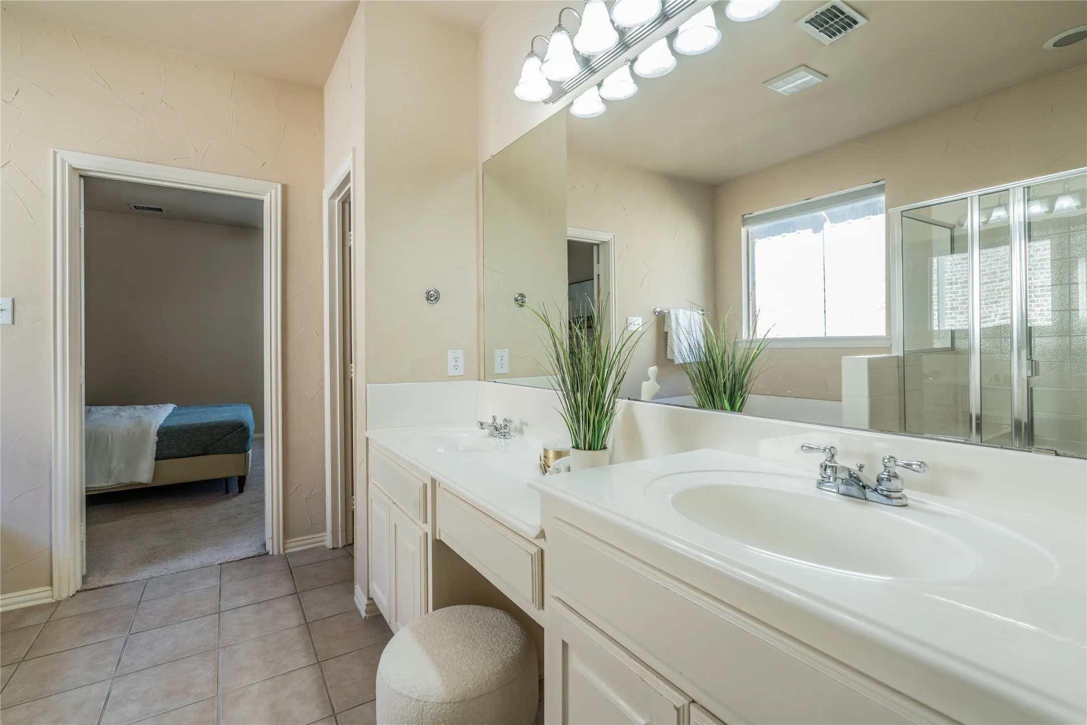 Primary bathroom with dual vanity with integrated sinks, chrome fixtures, and built-in cabinetry