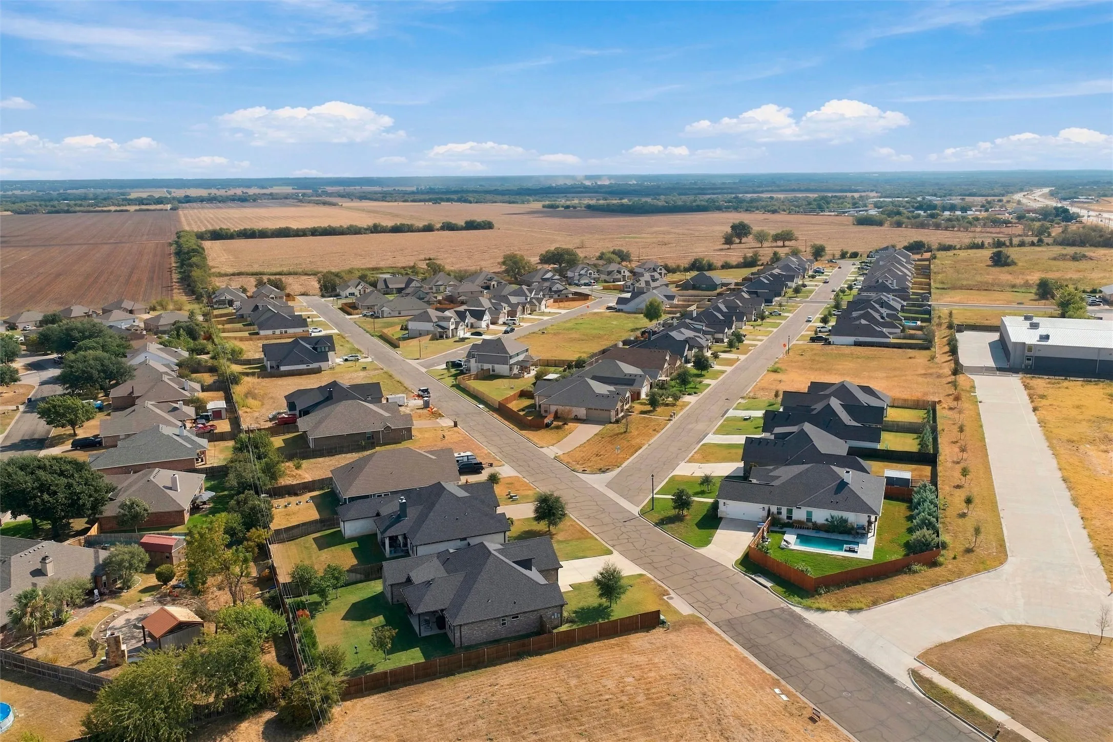 Residential community featuring a variety of single-story homes with dark-pitched roofs