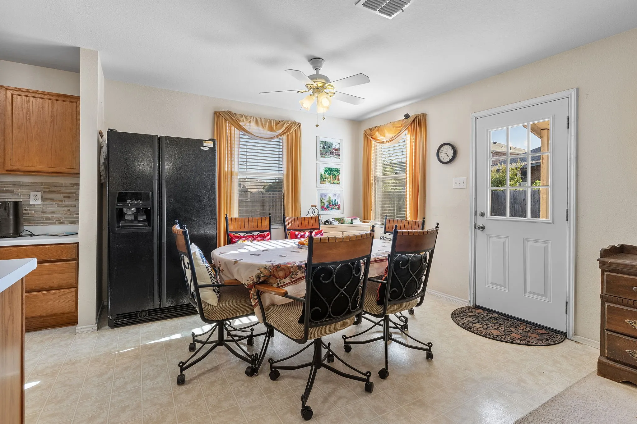 Kitchen area featuring wood cabinetry, tiled backsplash, and light-toned flooring