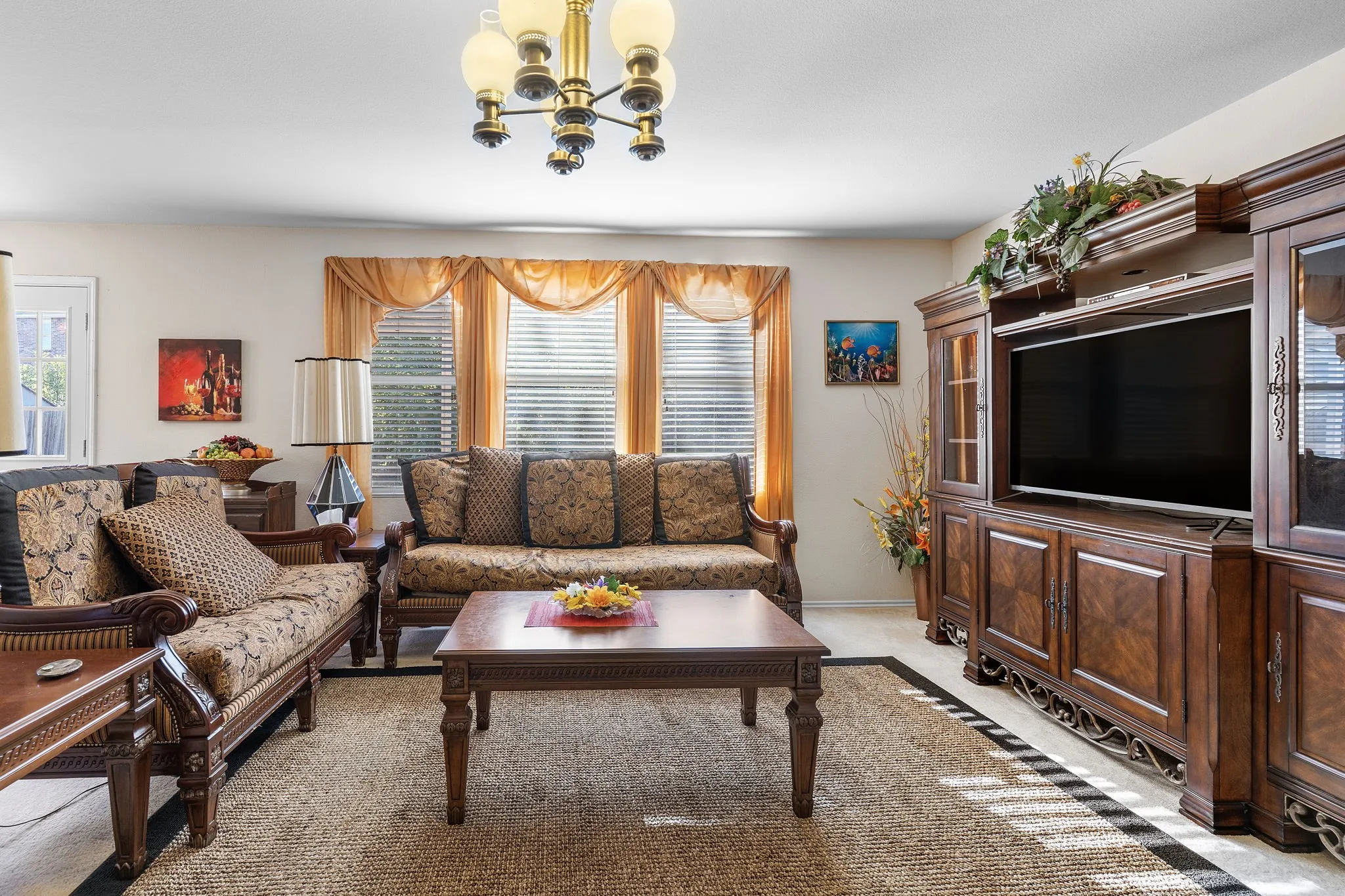 Recessed lighting, central chandelier, and window blinds