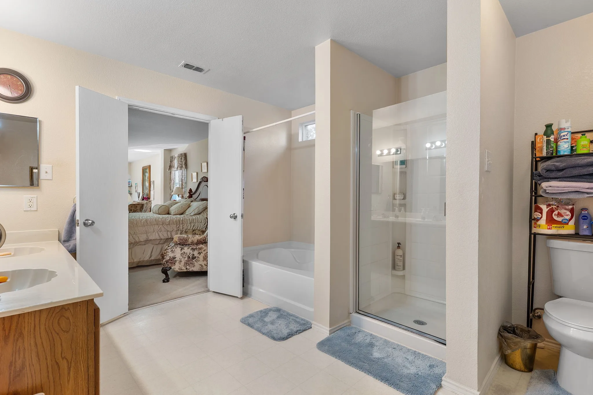 White-top vanity with a rectangular basin, wood-finish cabinetry, and a mirrored medicine cabinet