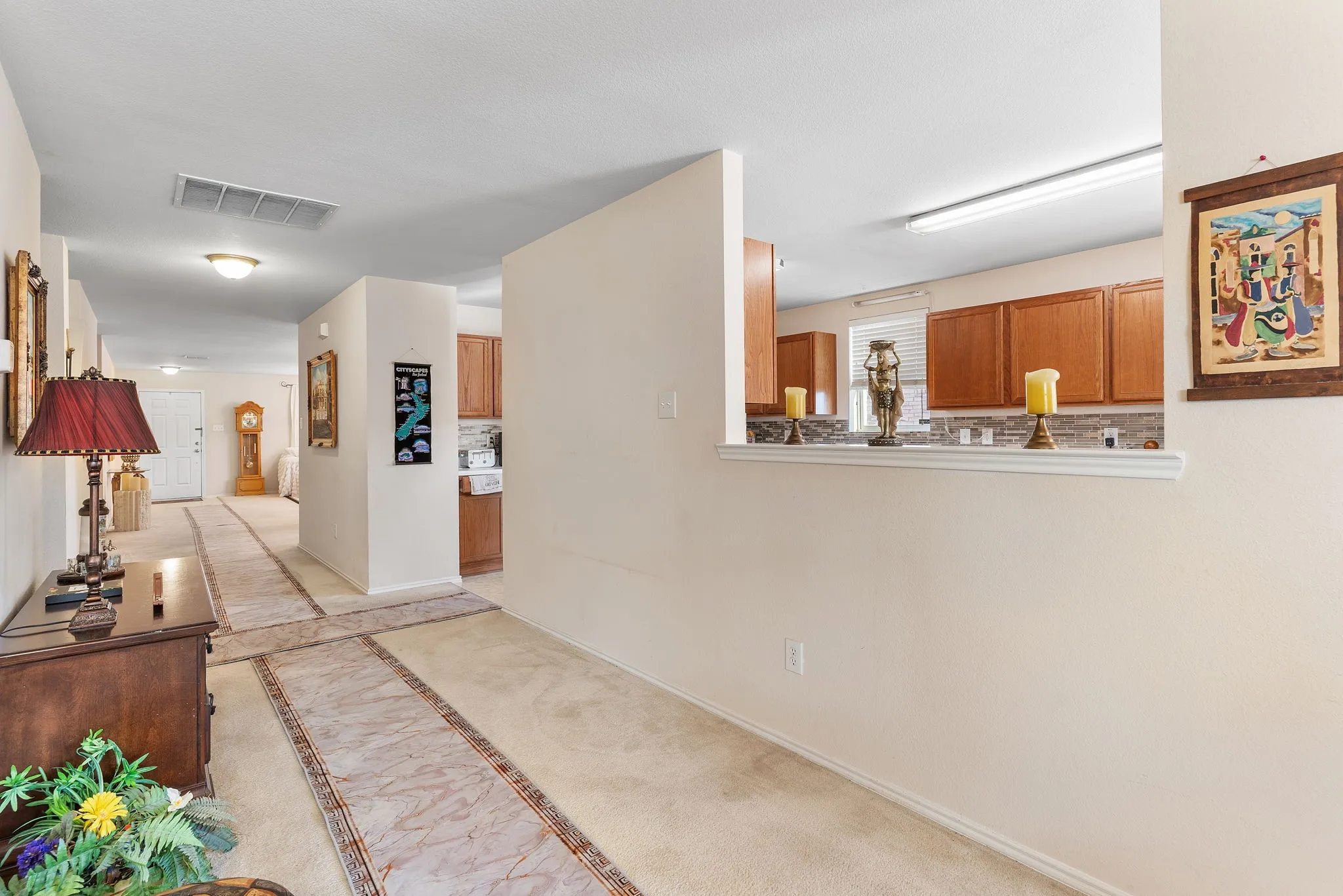 Kitchen pass-through with wood cabinetry and tile backsplash