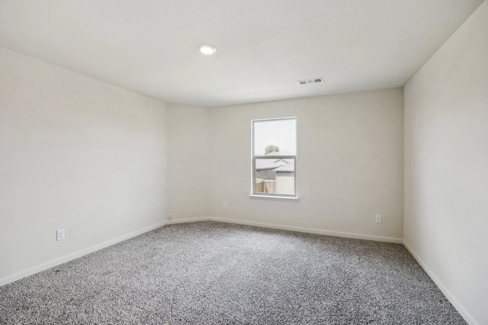 Recessed ceiling lighting, light gray wall paint, gray patterned carpeting, double-pane window, and white trim