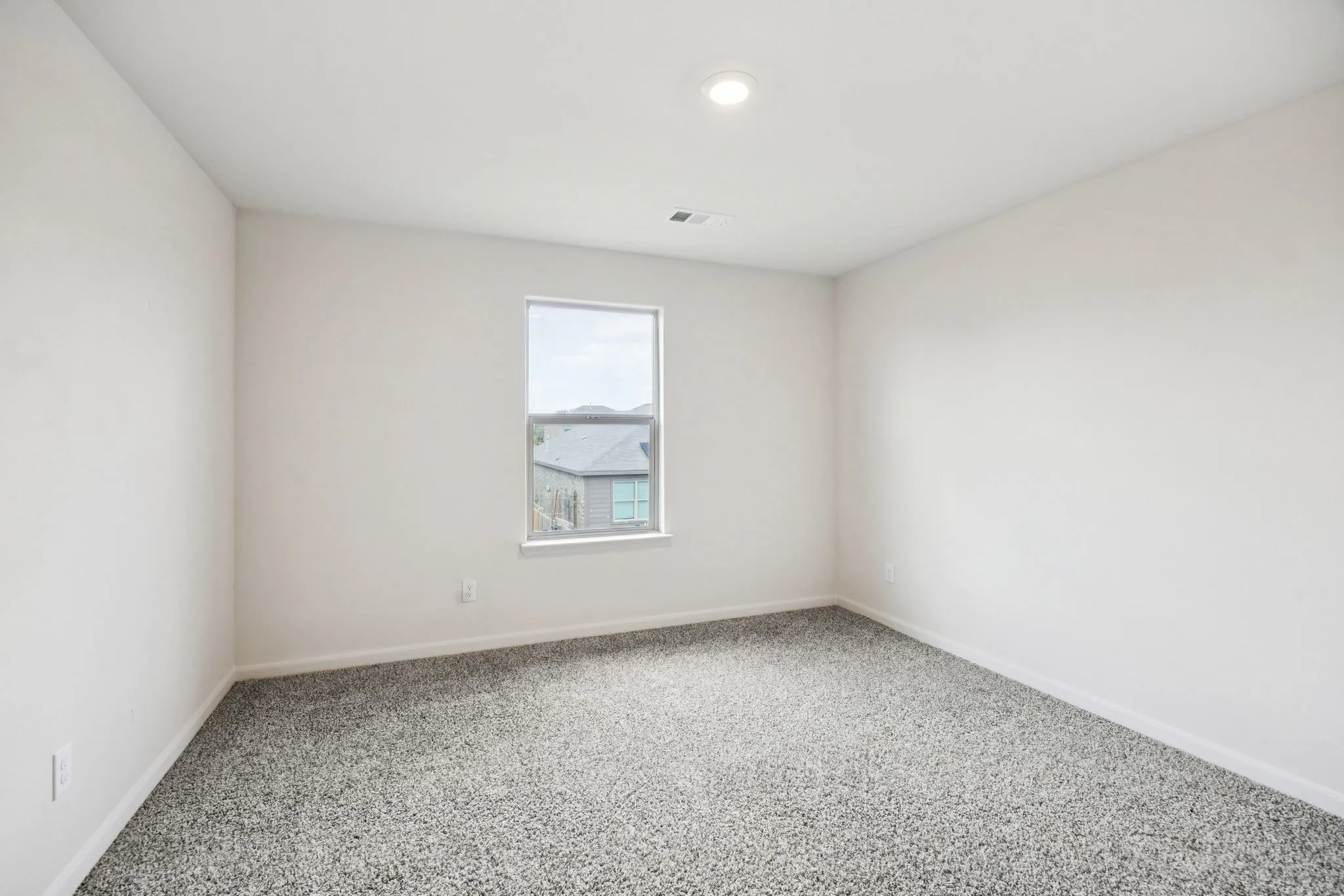 Recessed ceiling lighting, a single window, and neutral wall paint