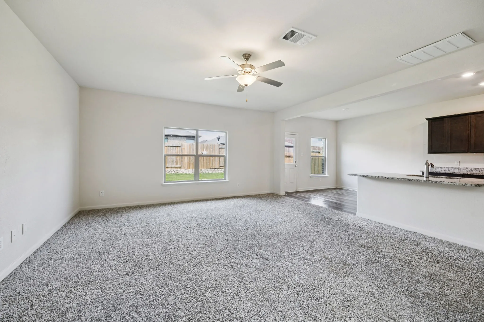 Spacious room with gray carpet flooring and white walls