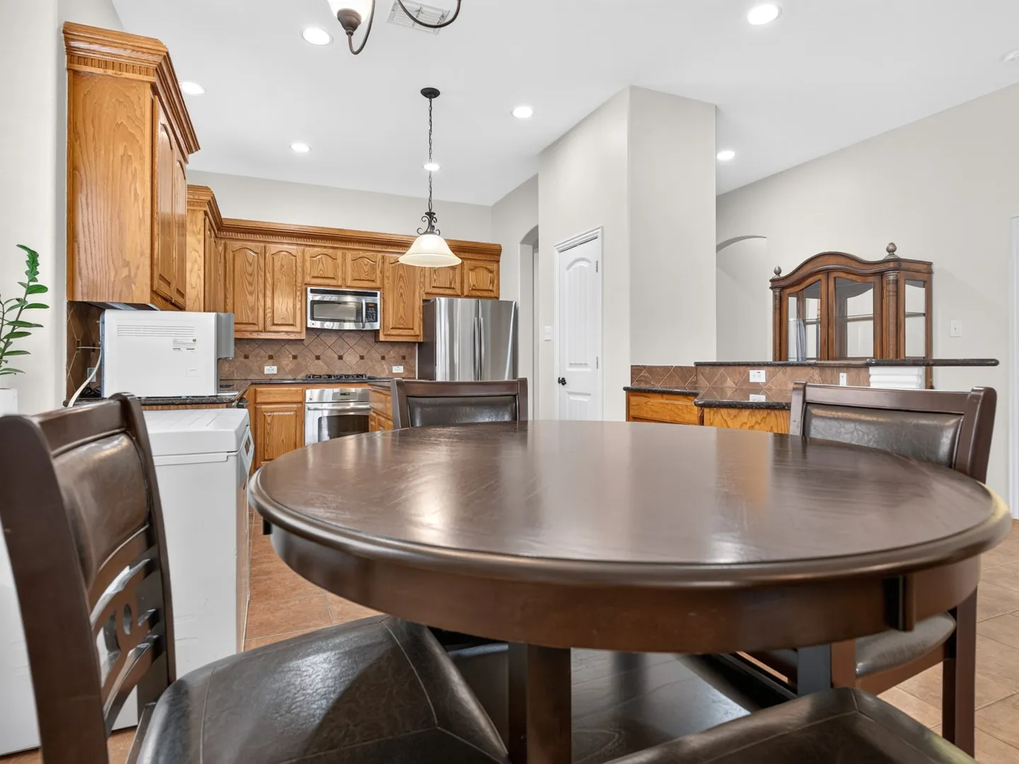 Kitchen featuring wood cabinetry, stainless steel appliances, and a tiled backsplash
