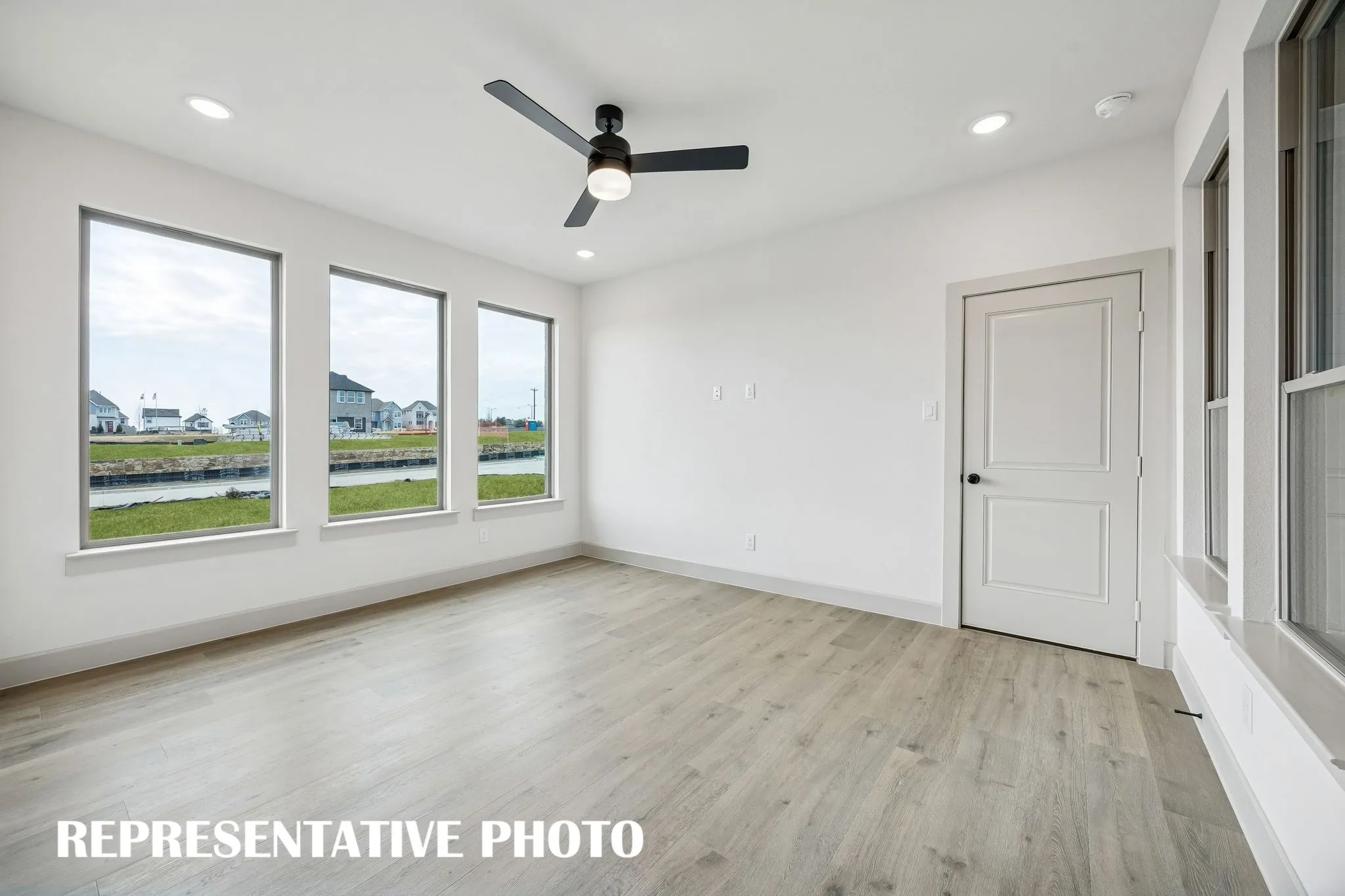 A wall of windows floods this family room with natural light creating a bright and inviting space.  REPRESENTATIVE PHOTO