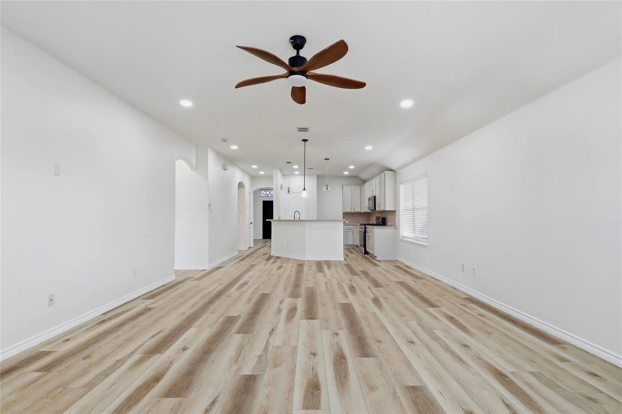 Wood-finish flooring, recessed lighting, and a ceiling fan