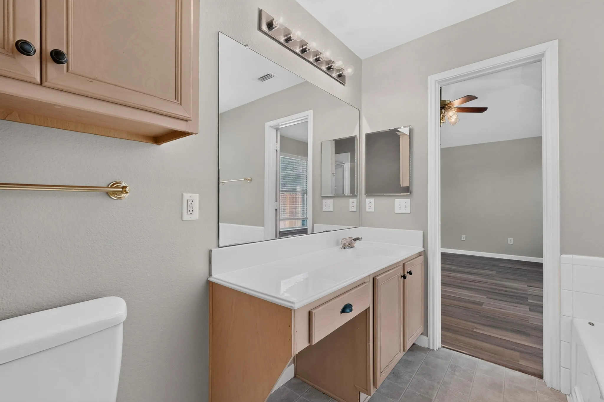 Built-in vanity with integrated sink, overhead mirror, and light fixture