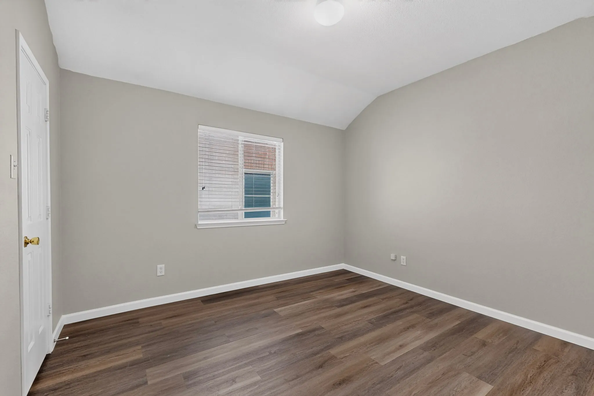 Wood-finish flooring, white trim, neutral wall color, window with blinds, and ceiling-mounted light fixture