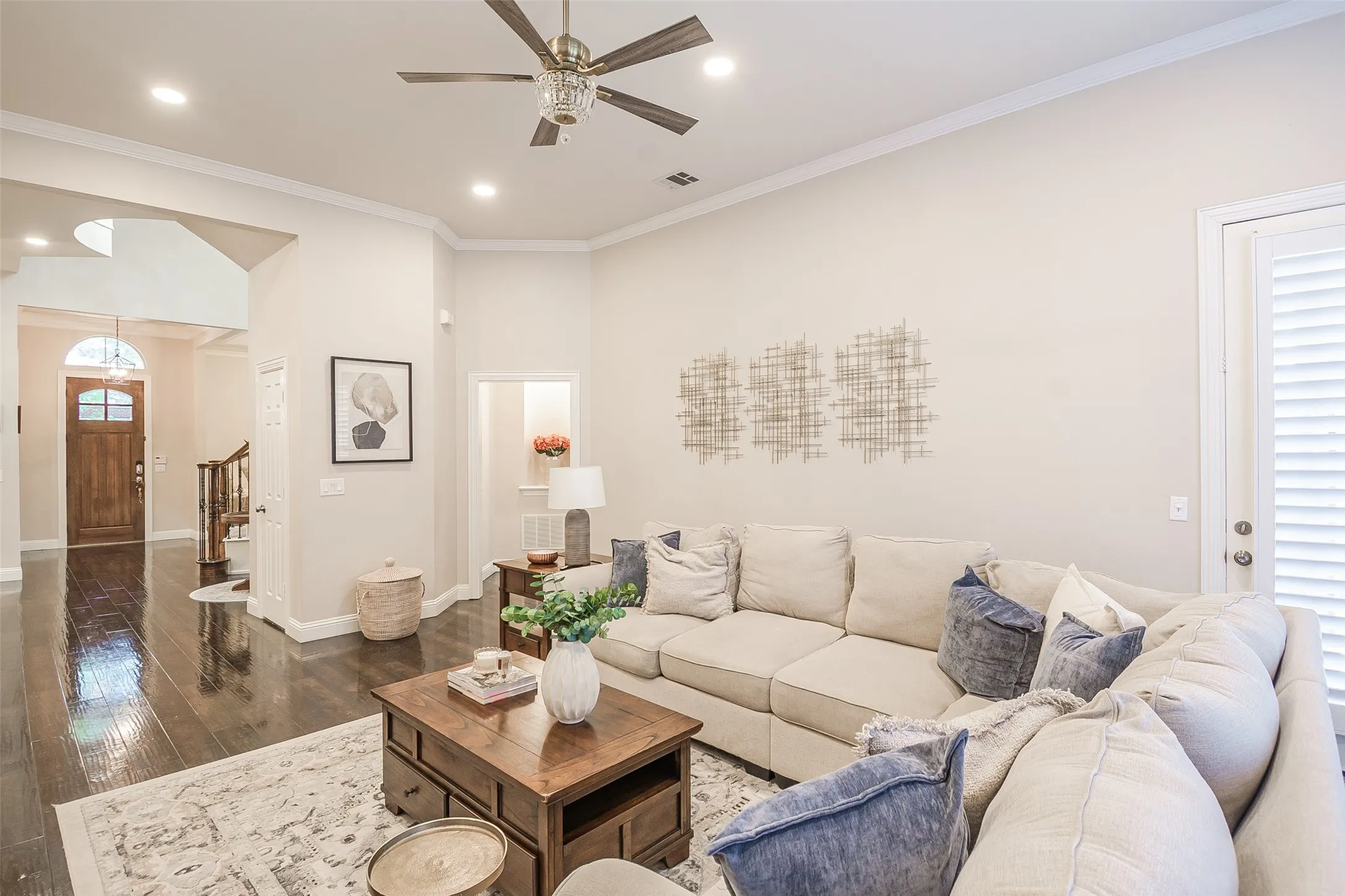 Wood-finish flooring, recessed lighting, ceiling fan, crown molding, and plantation shutters