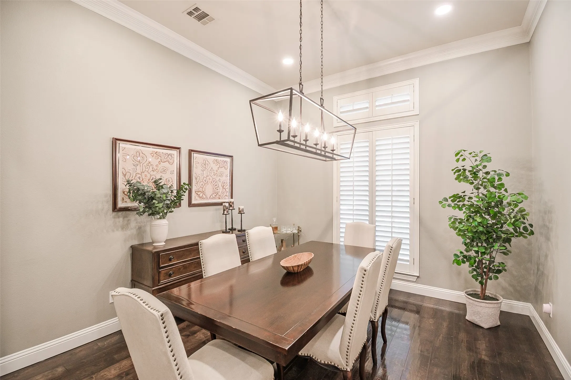 Recessed lighting, crown molding, wood-finish flooring, plantation shutters, and a linear chandelier