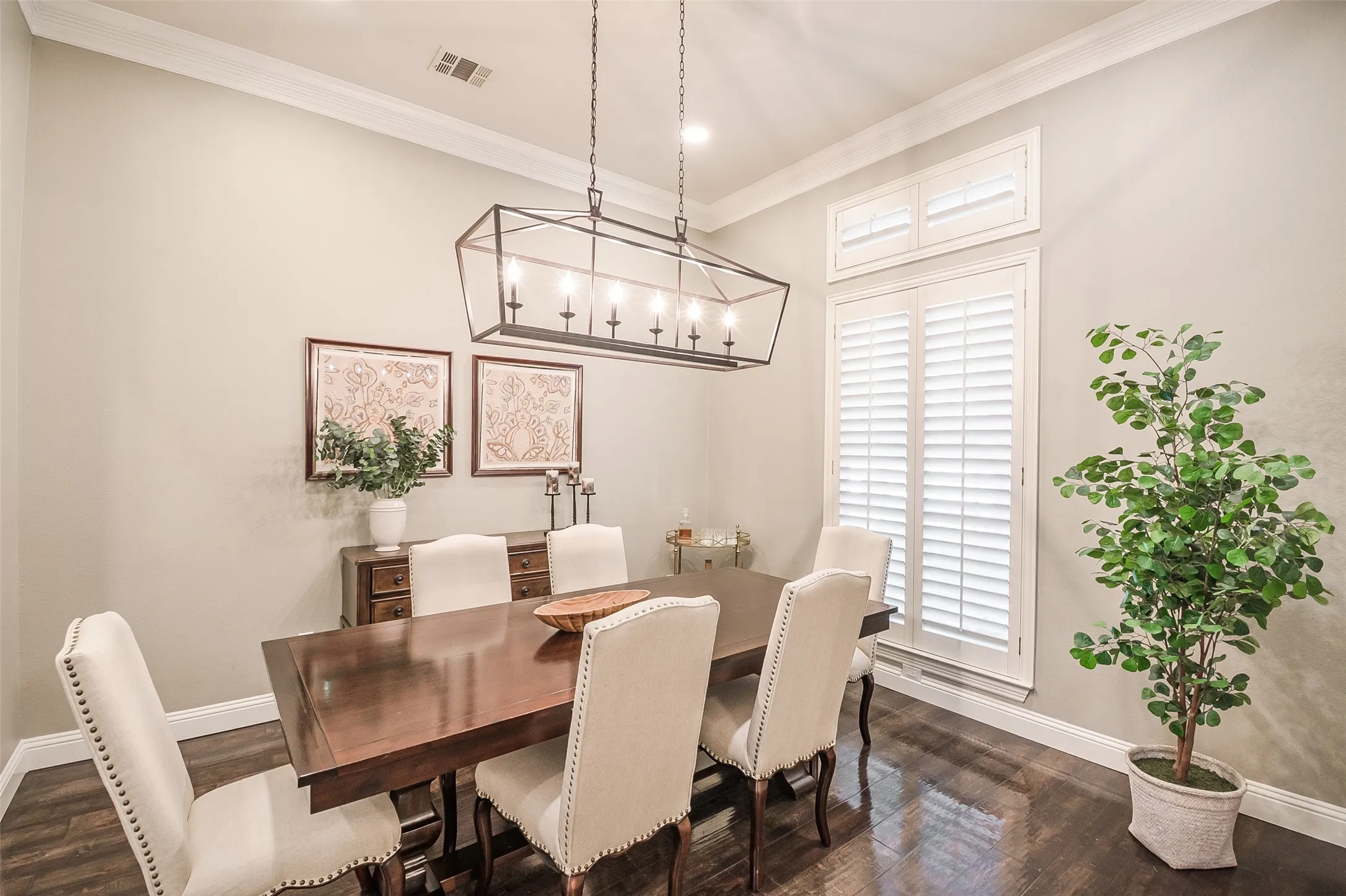 Crown molding, wood-finish flooring, recessed lighting, plantation shutters, and a linear chandelier