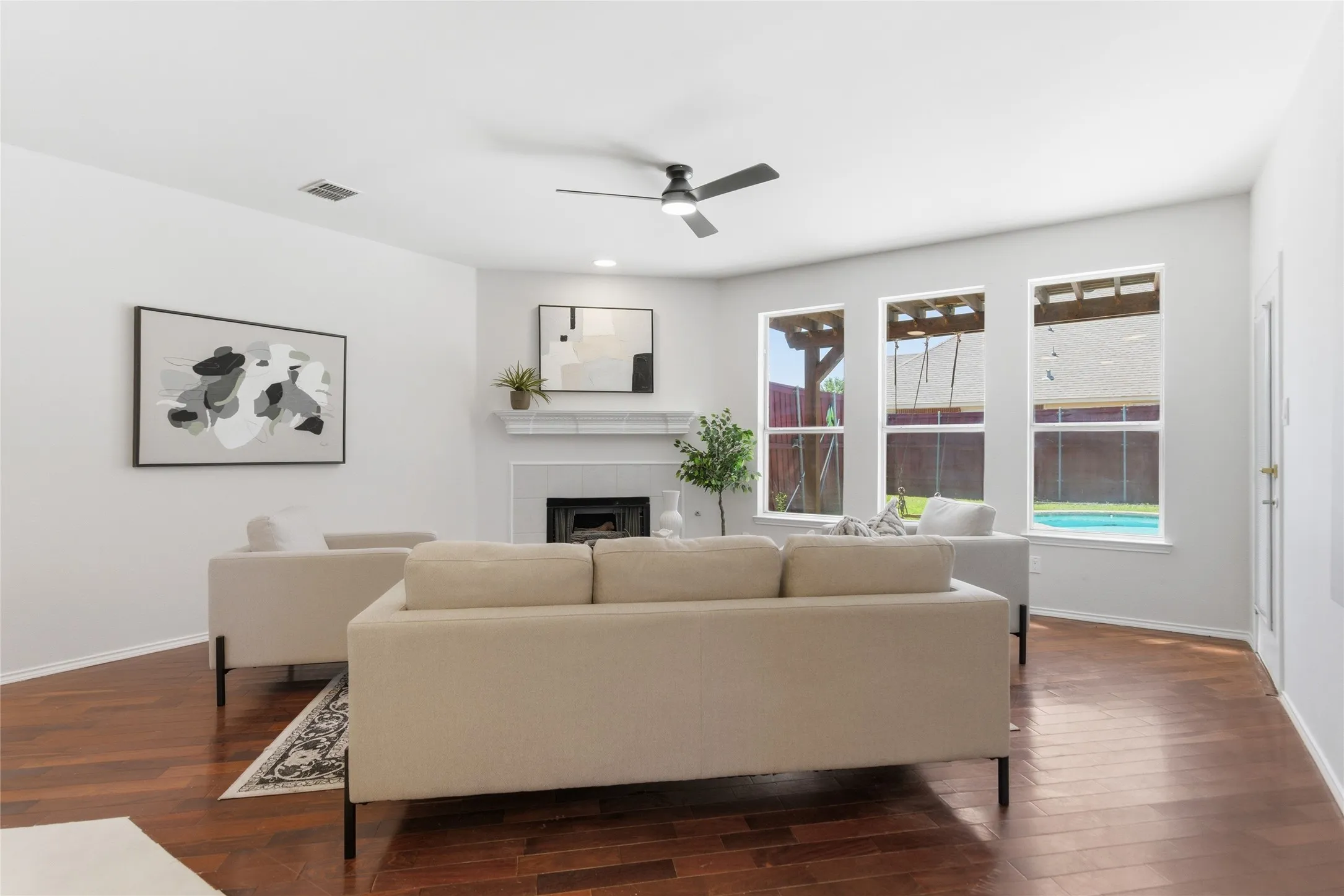 Living area with wood-finish flooring, a white mantel, and a fireplace