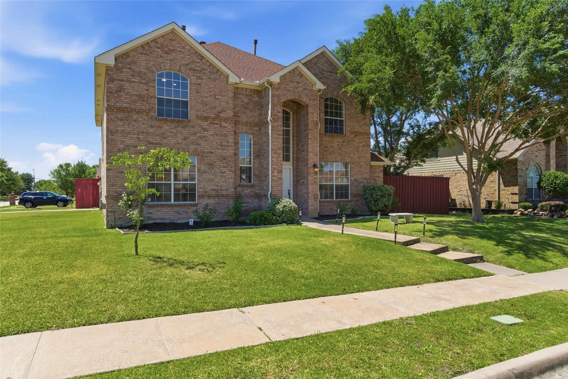 Brick exterior with arched windows, gabled roof, and a concrete walkway