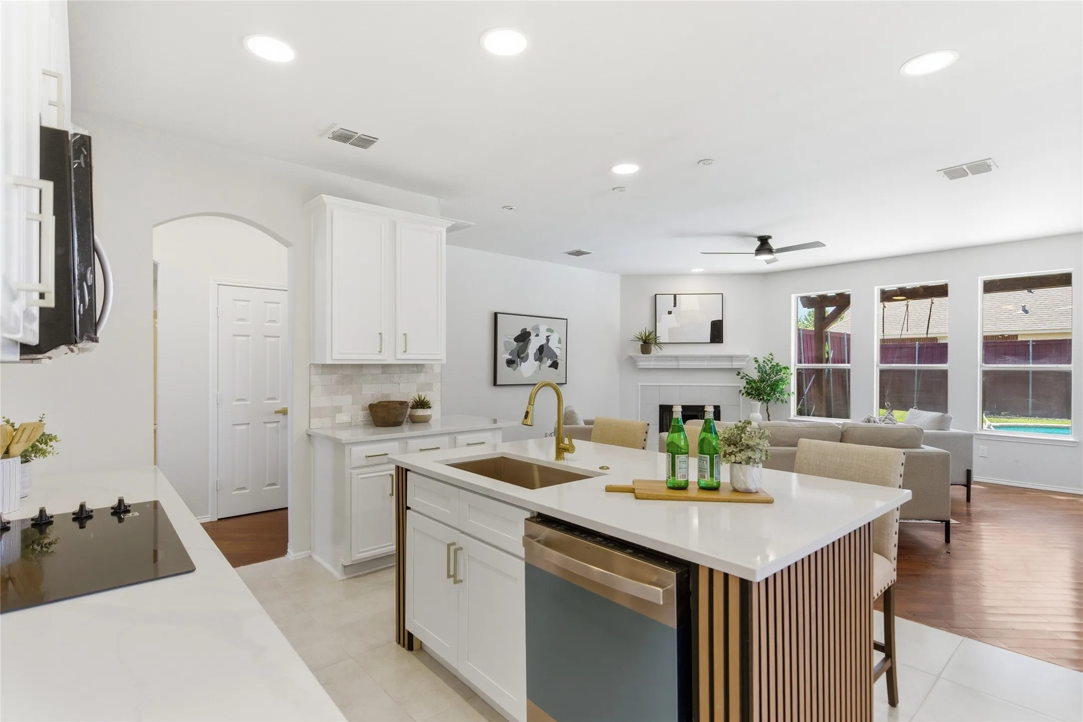 Open-concept living area featuring a kitchen island with seating, a built-in cooktop, and a fireplace in the living space