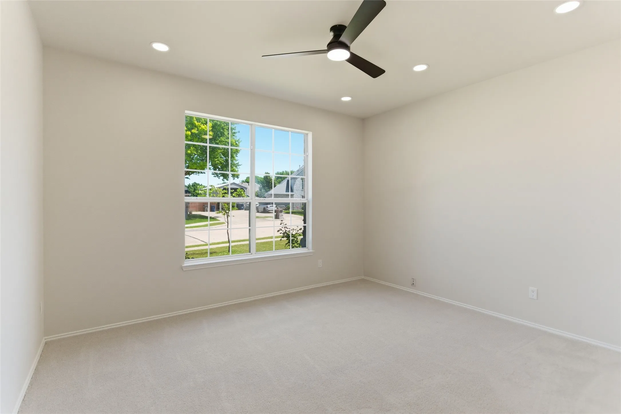 Recessed lighting, ceiling fan, and large window with grid pattern