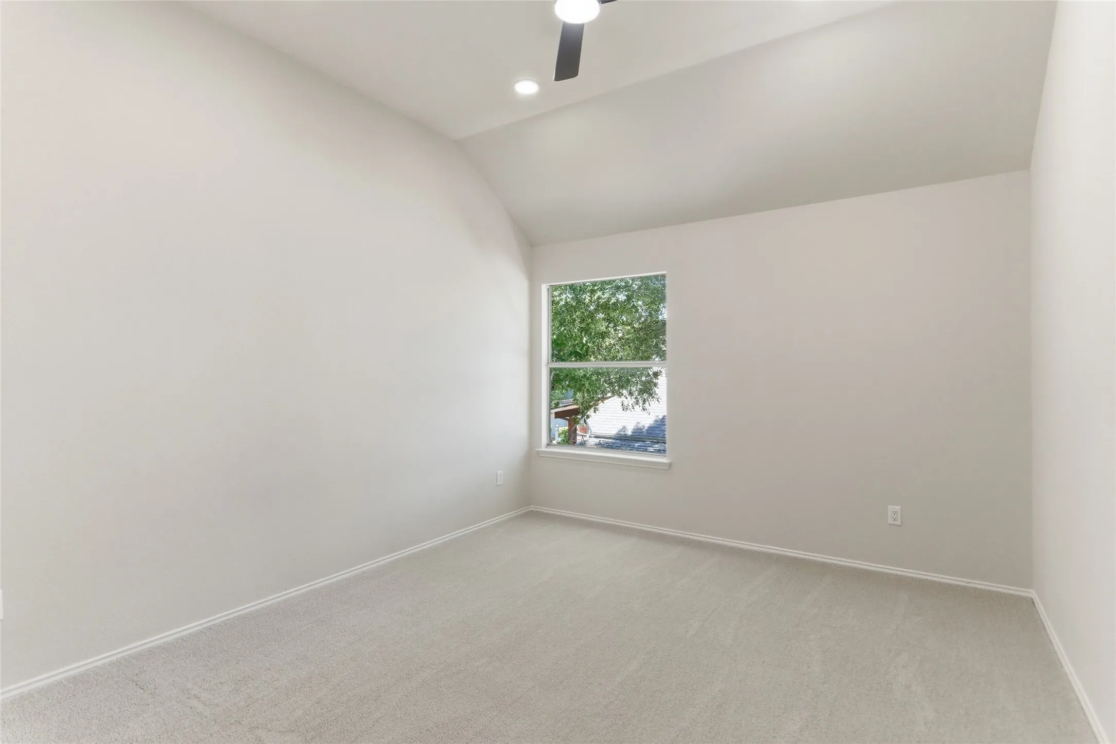 Vaulted ceiling, recessed lighting, ceiling fan, carpet flooring, and a window