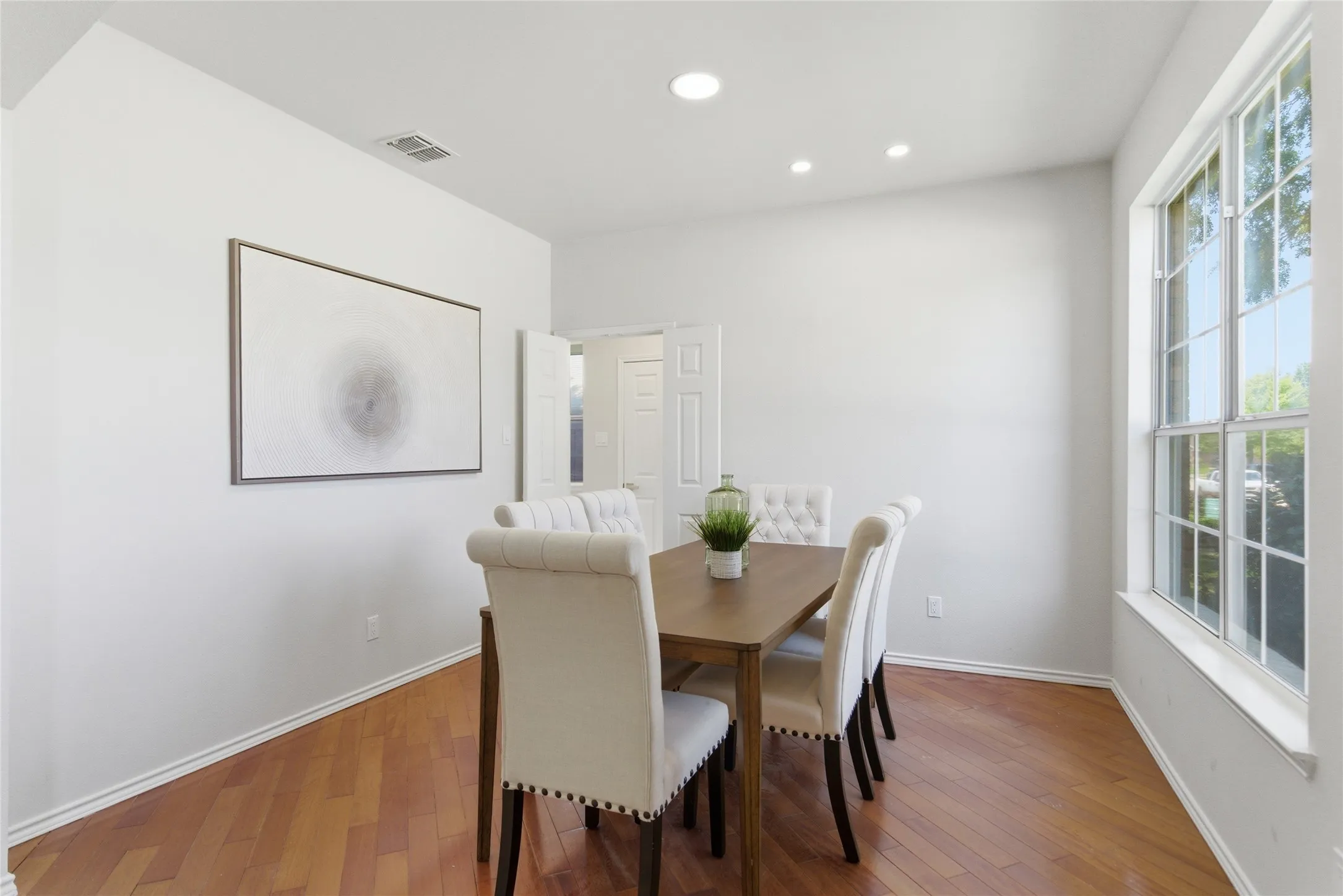 Hardwood flooring, recessed lighting, double pane window, and light-toned walls