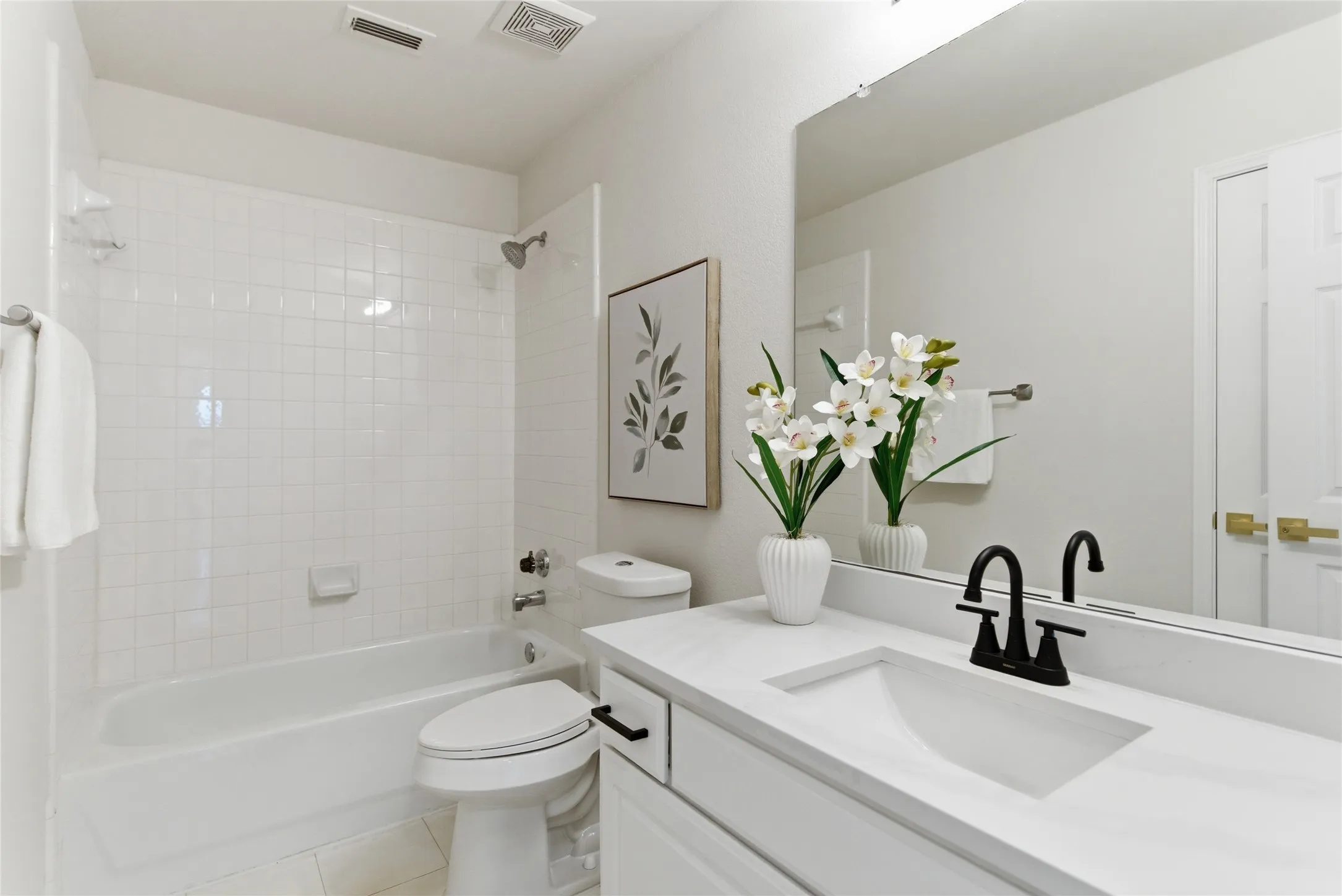 White vanity with an integrated rectangular sink, matte black faucet, and large wall-mounted mirror