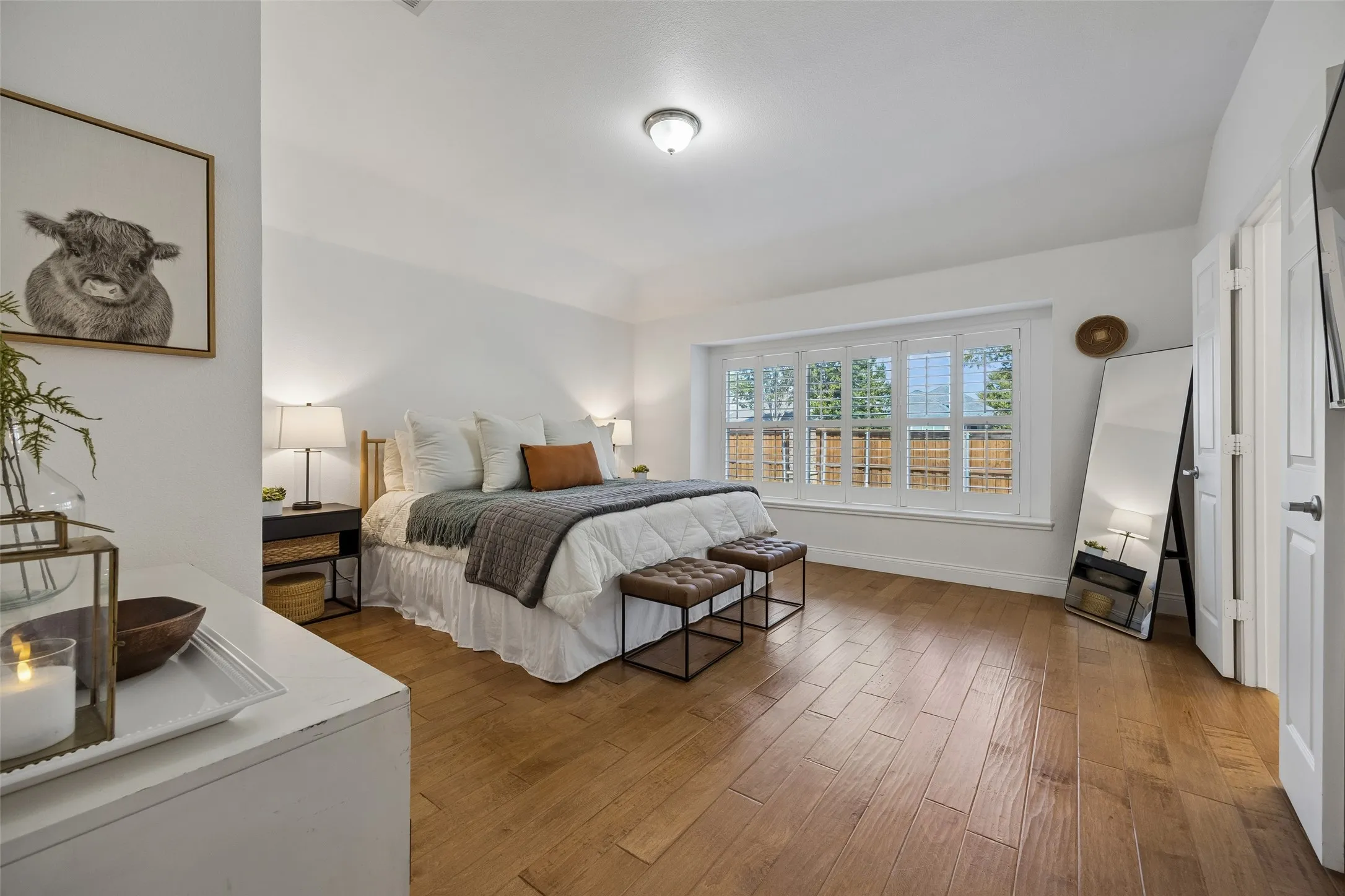 Peaceful primary suite with warm flooring, a vaulted ceiling and plenty of natural light.