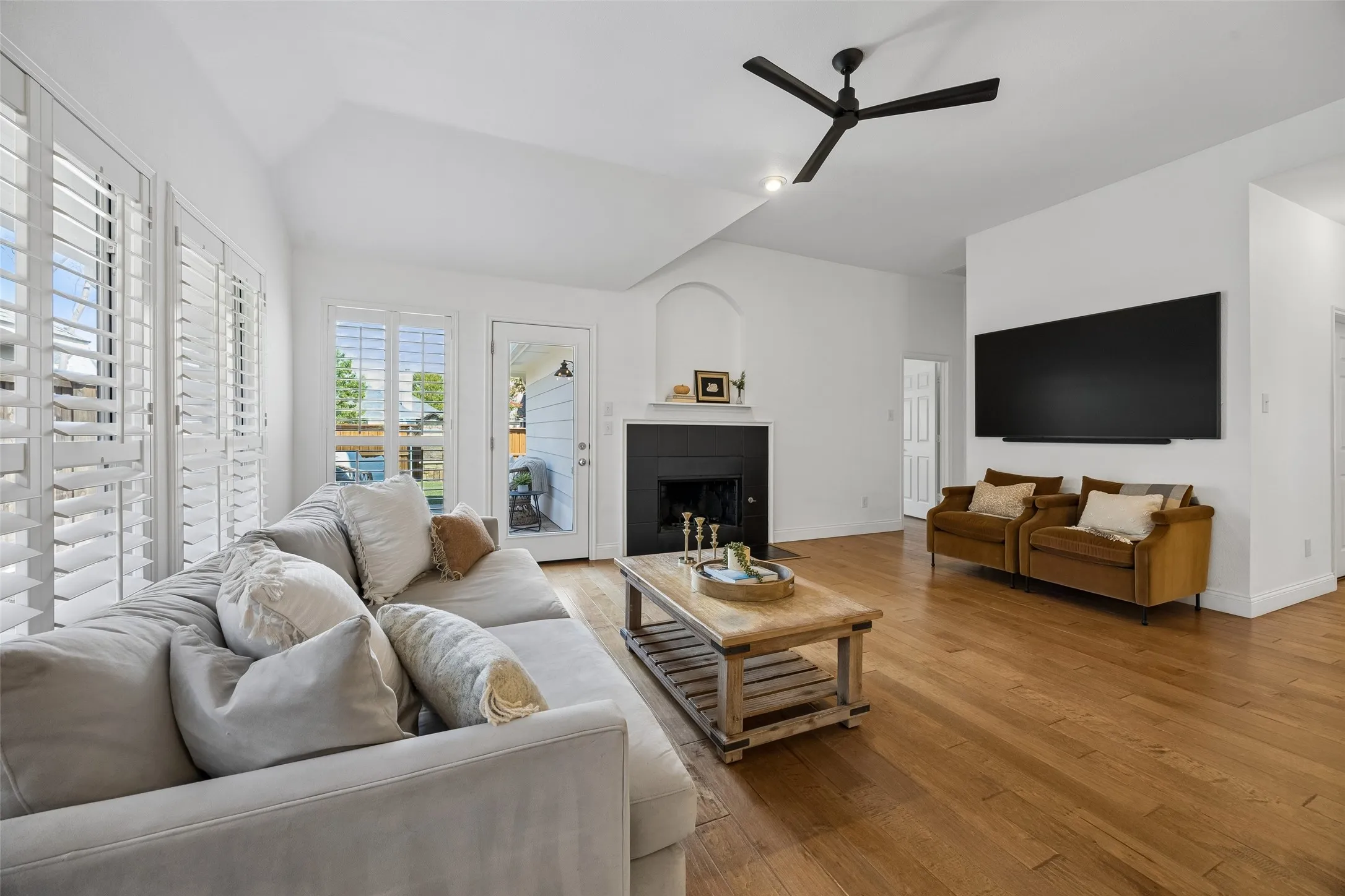 Bright and comfortable family room with warm wood flooring and a cozy gas start fireplace.