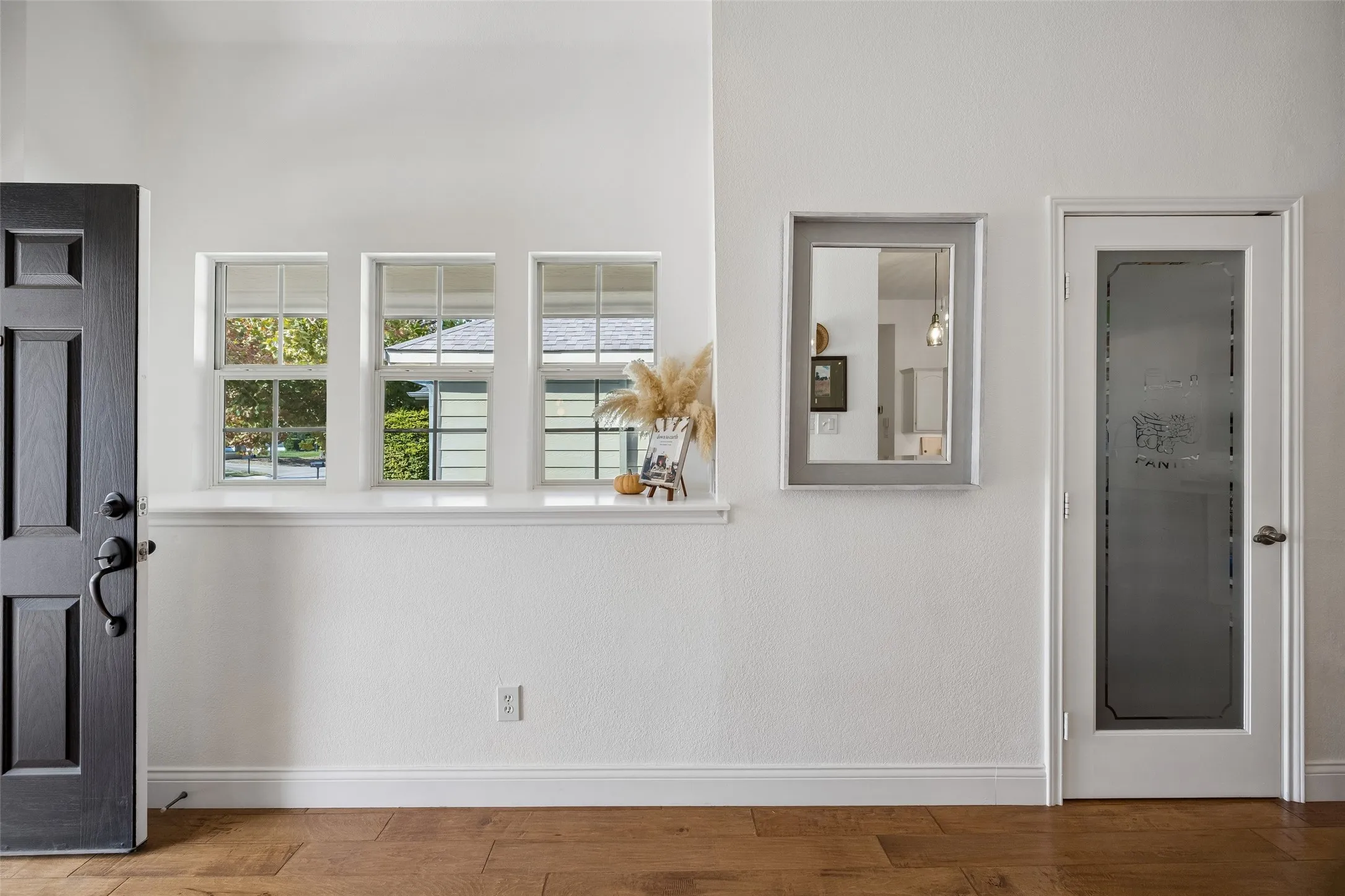 I love this chic entry with window ledge and a fun pantry door this home has so much cute style!