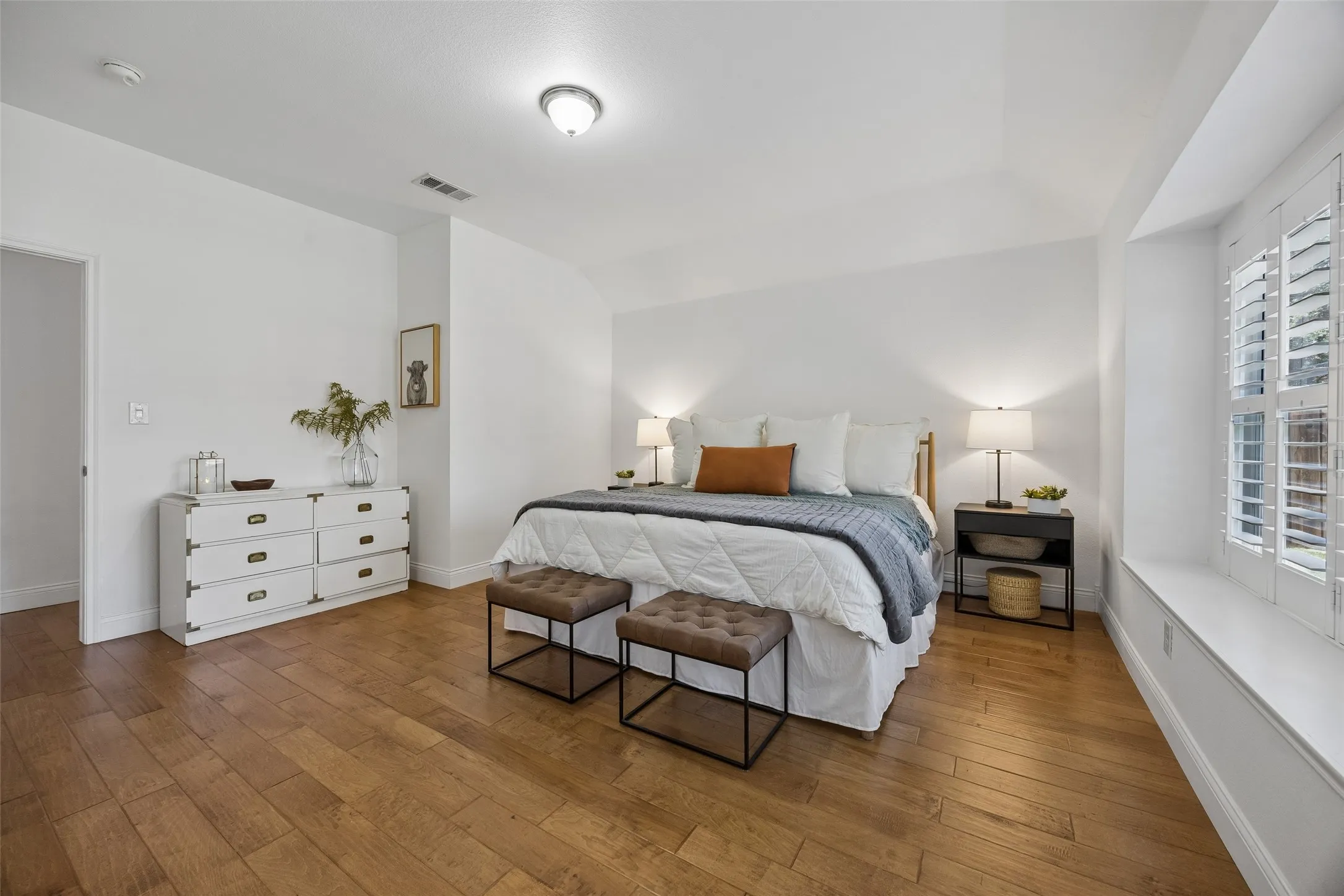 Another view of the spacious primary suite showcasing its warm modern transitional style.