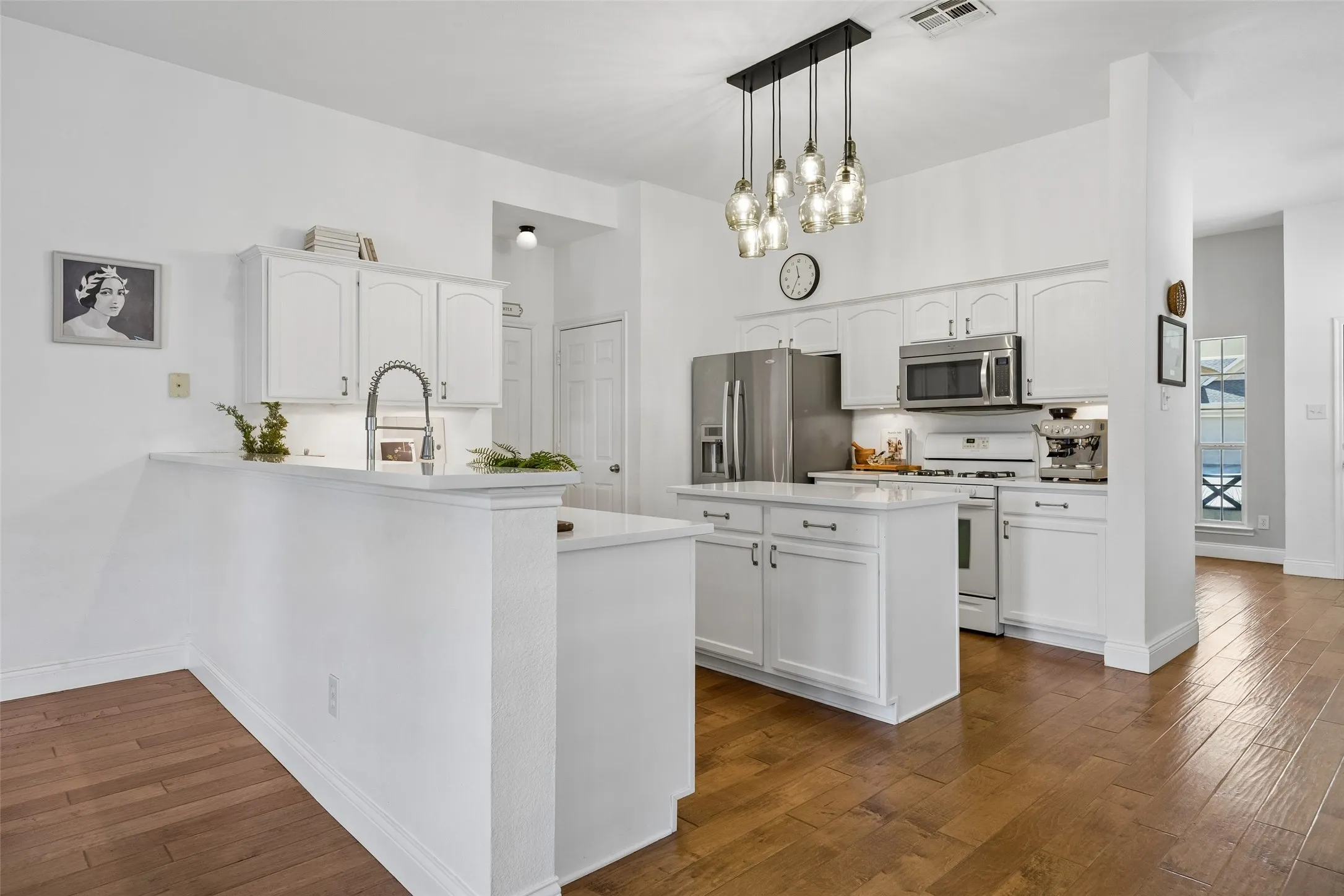 Beautifully updated kitchen with white cabinetry, quartz countertops and a spacious island.