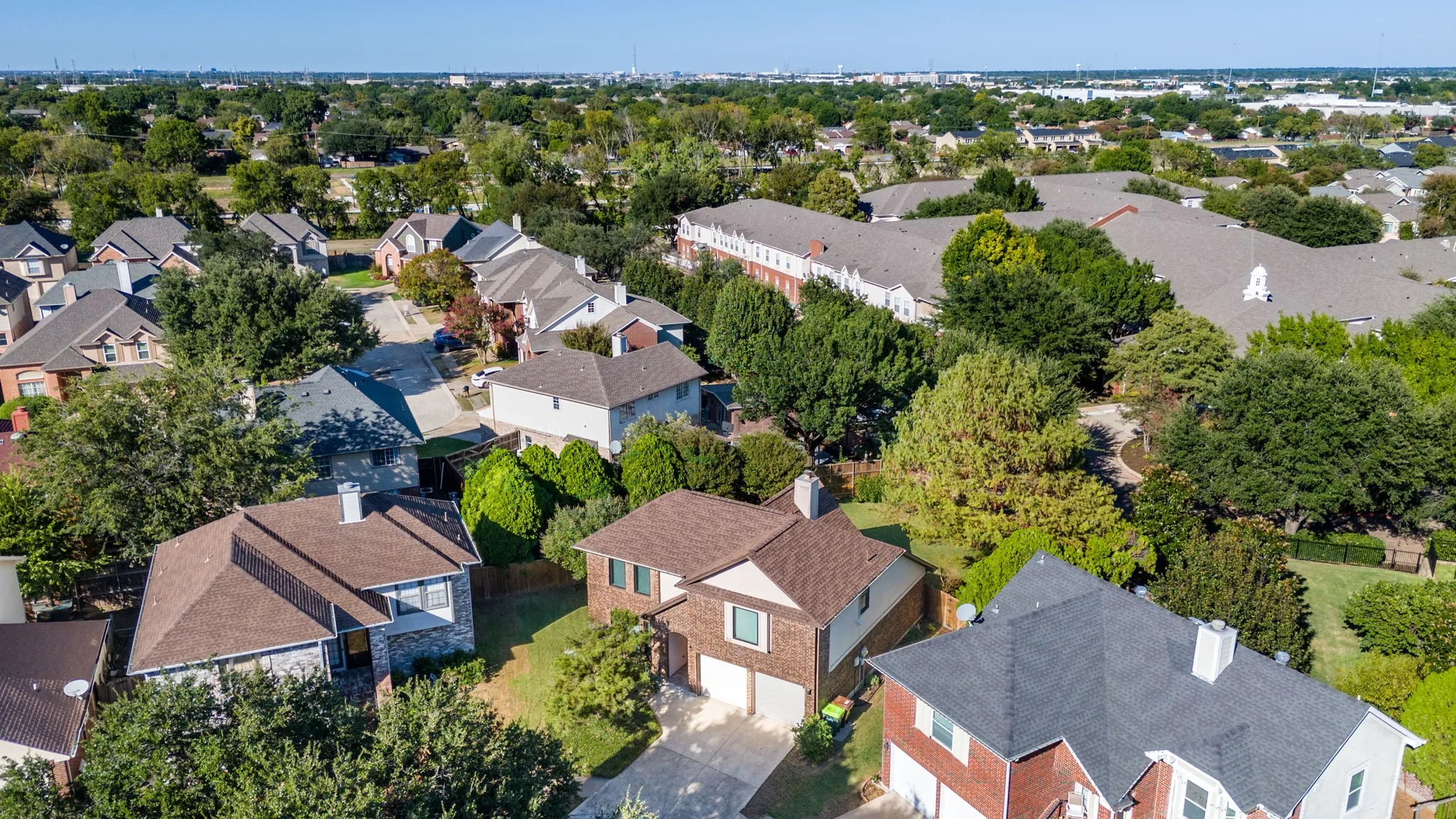 Residential neighborhood with mature trees and a mix of roof styles