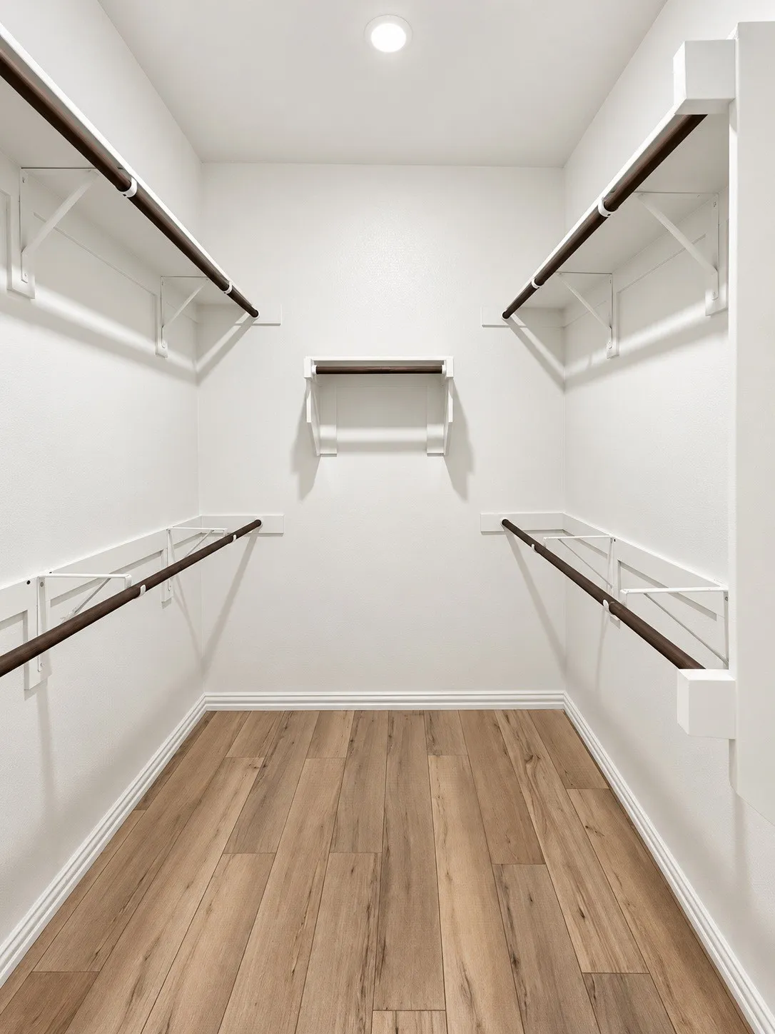 Walk-in closet with wood-finish flooring, recessed lighting, and white built-in shelving with hanging rods