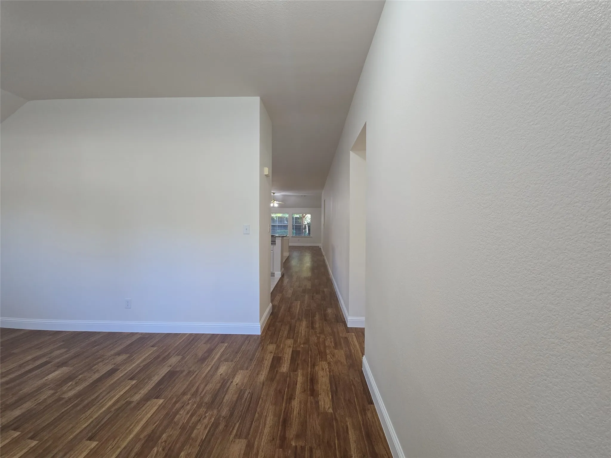 Wood-finish flooring throughout, bright white walls, and a recessed ceiling