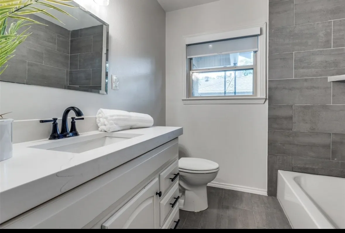 White vanity with a rectangular undermount sink, quartz countertop, and matte black faucet