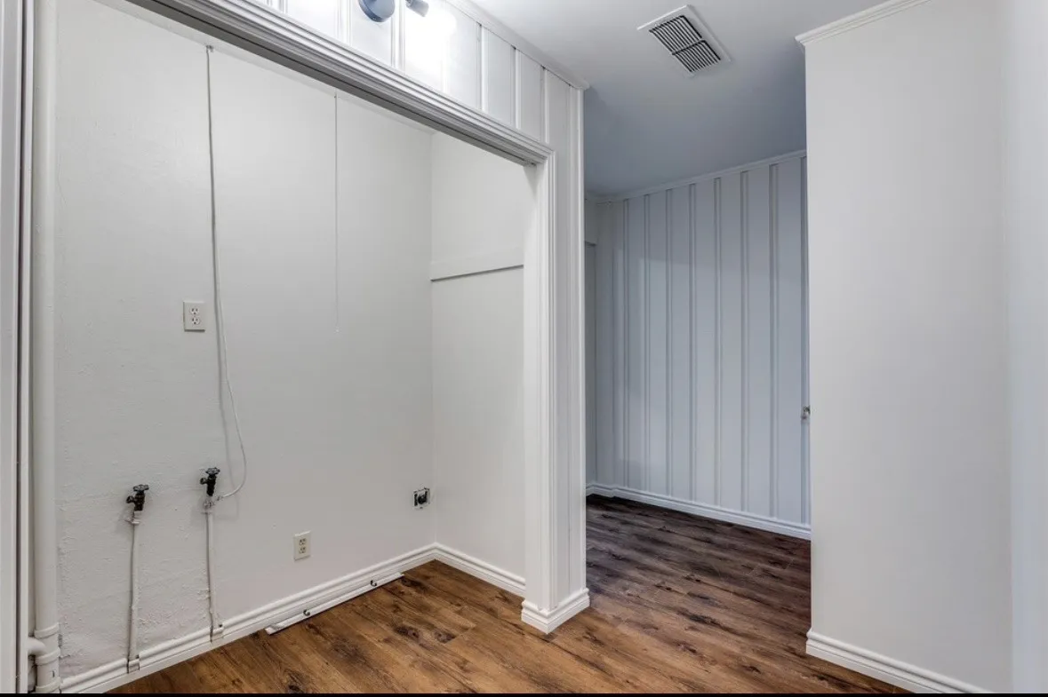 Utility area with wood-finish flooring and integrated washer/dryer connections